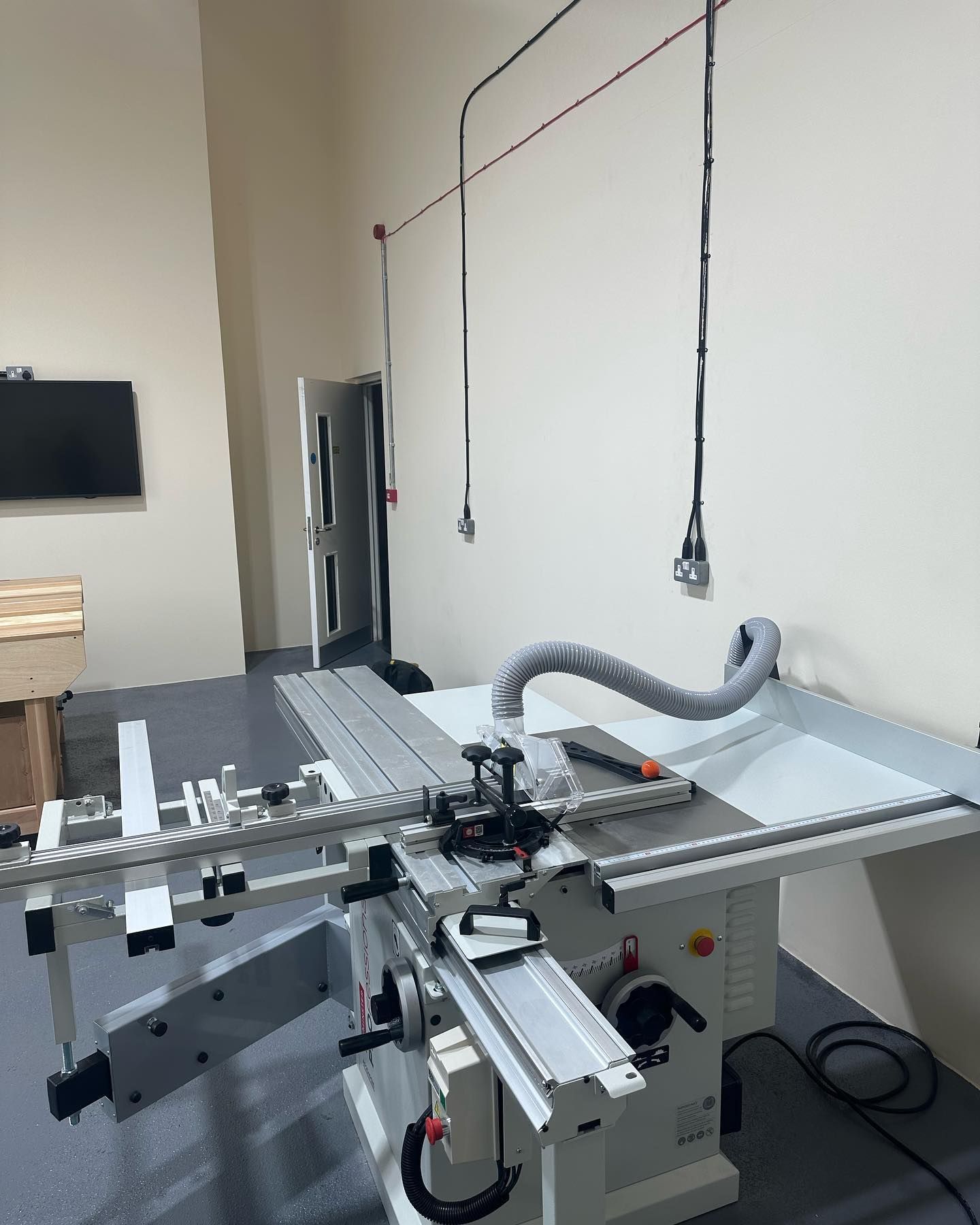 A table saw with a hose attached to it in a room