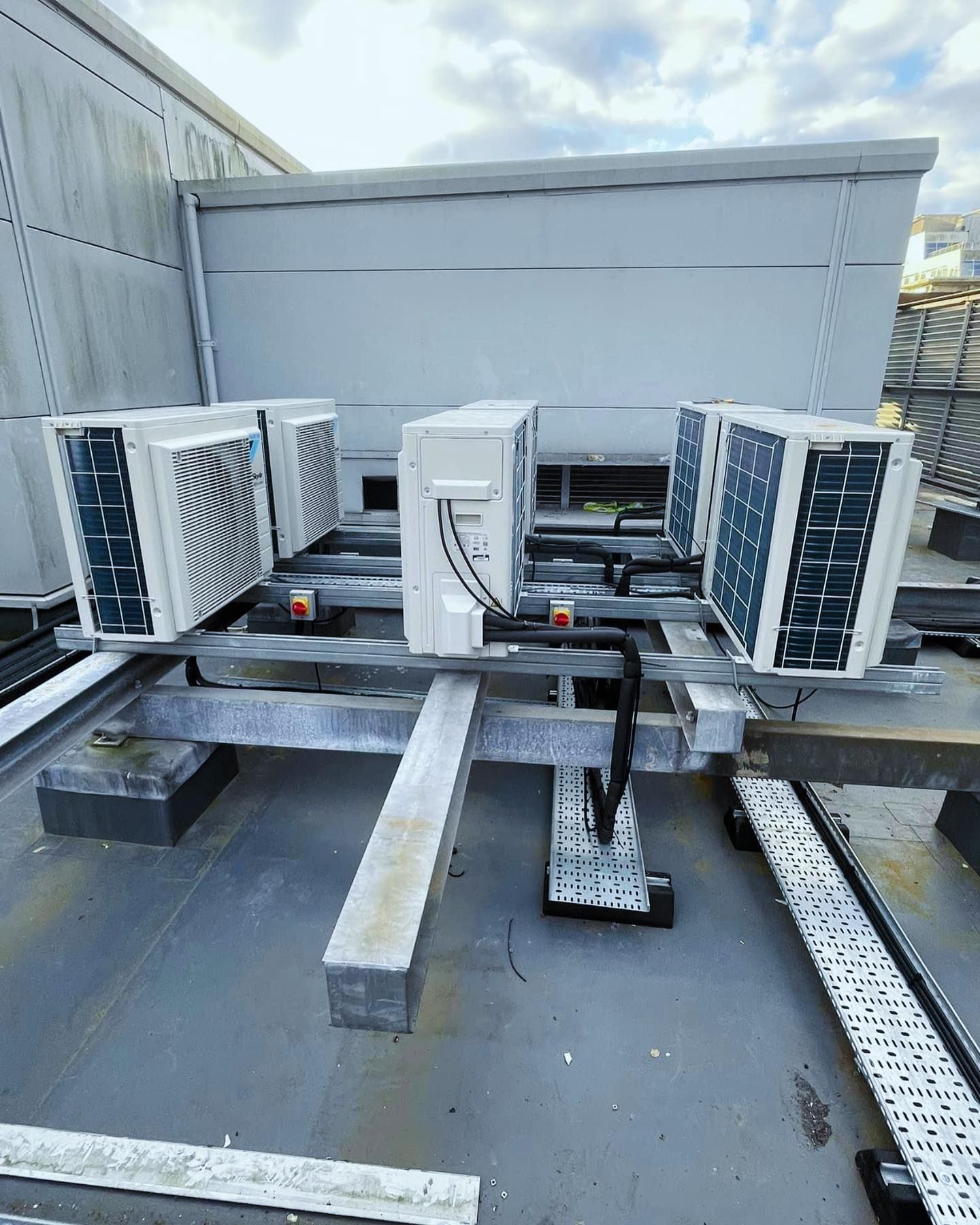 A bunch of air conditioners are sitting on top of a roof.