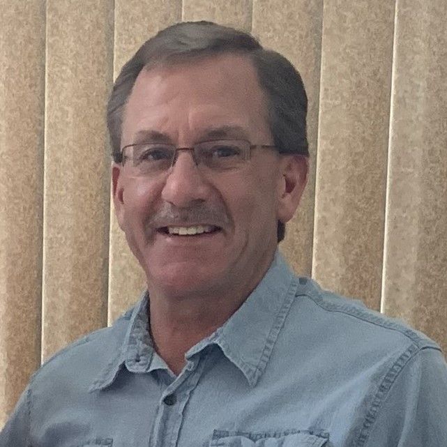 A silhouette of a person without a face on a gray background.