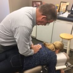 A man is giving a woman a massage on a table.
