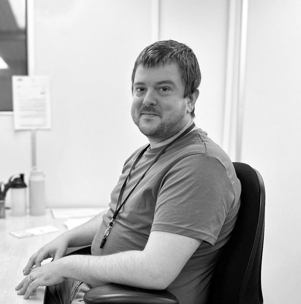 A man with a beard is sitting in an office chair
