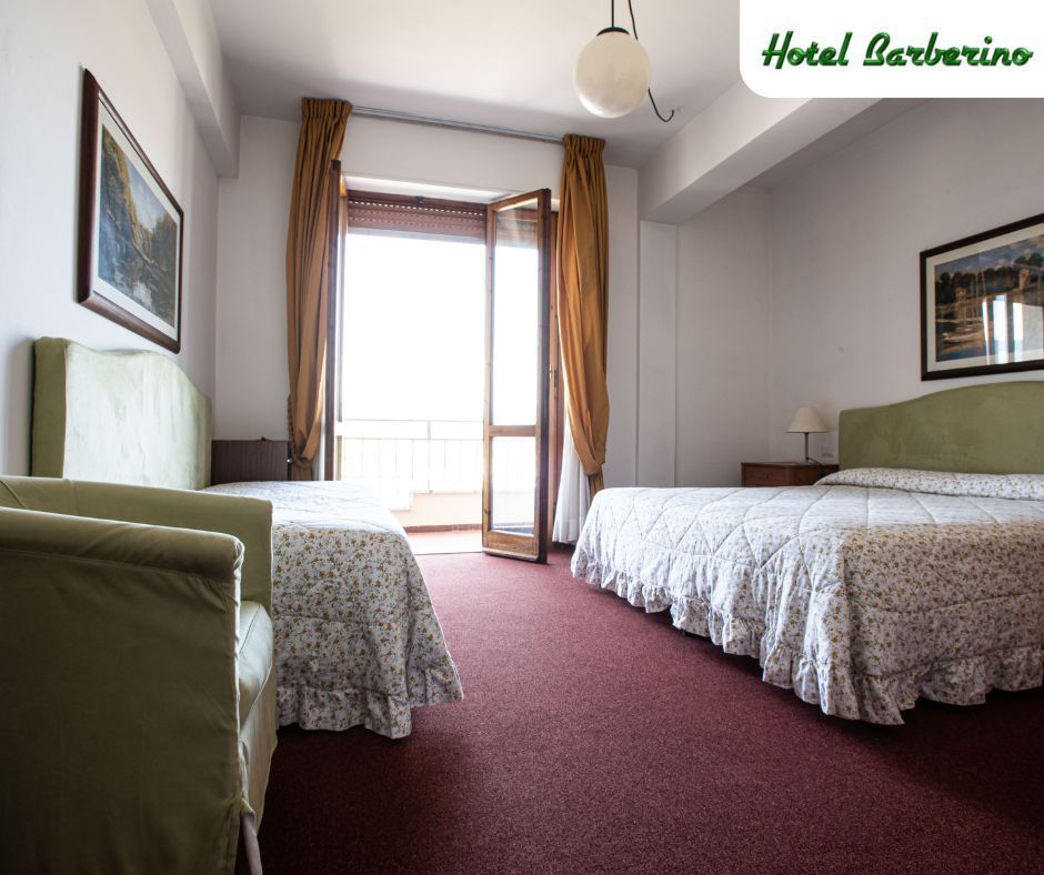 Una camera d'albergo con due letti e una sedia verde