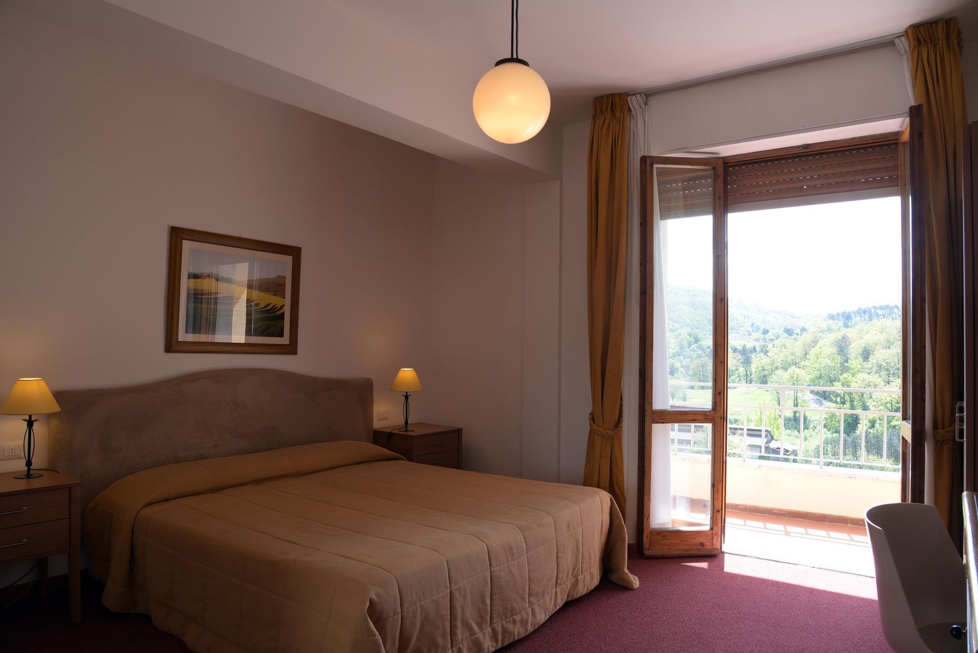 Una camera d'albergo con un letto grande e un balcone