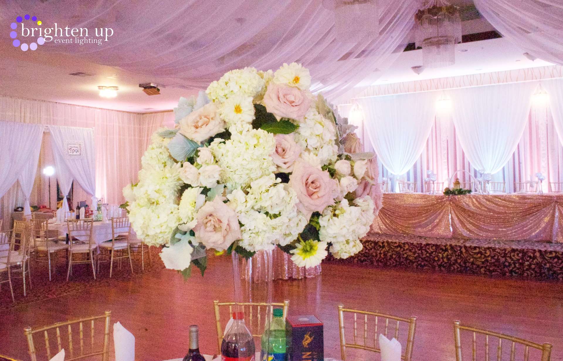 A large vase filled with flowers is sitting on a table in a room.