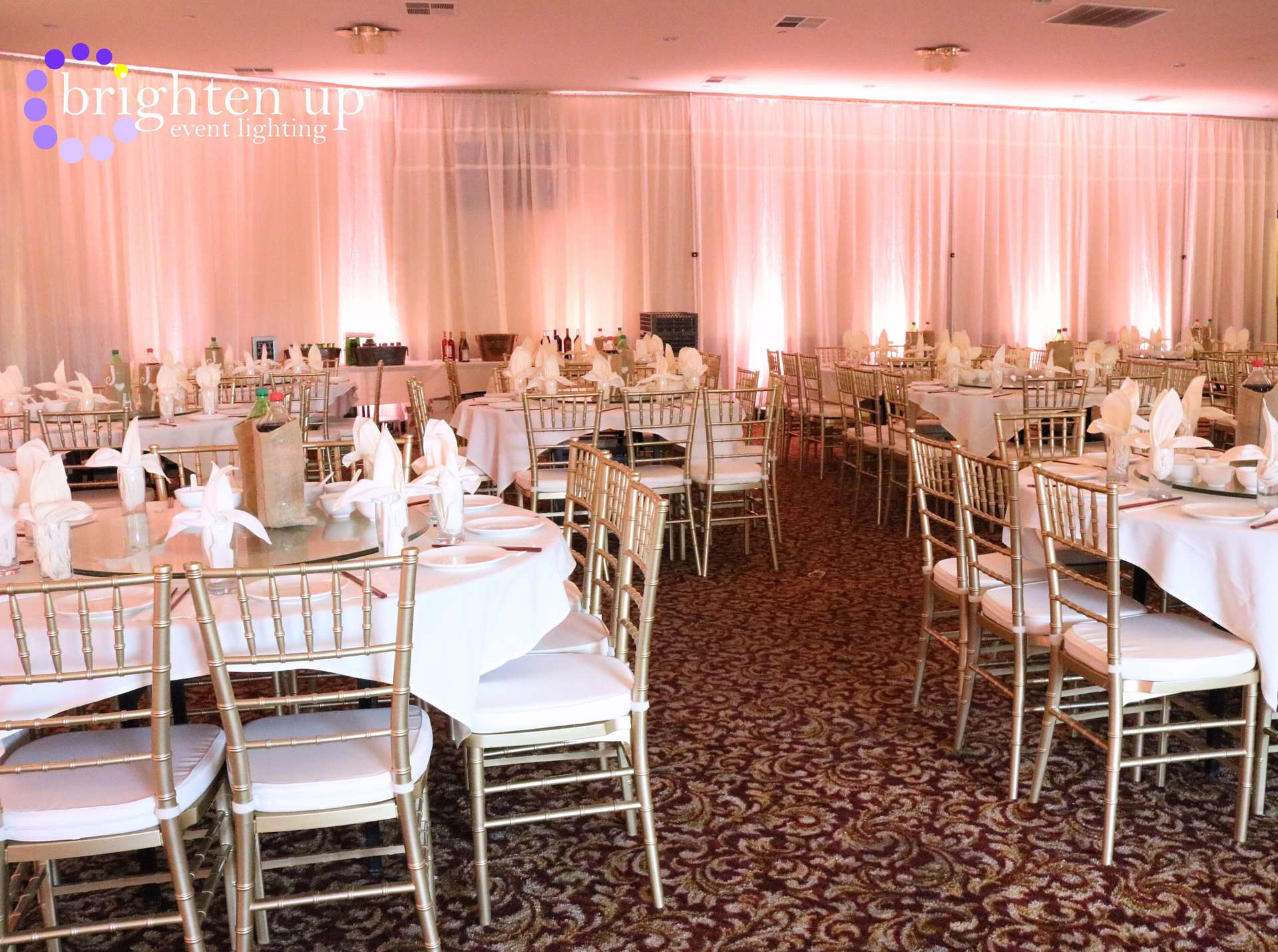 A large room with tables and chairs set up for a wedding reception.
