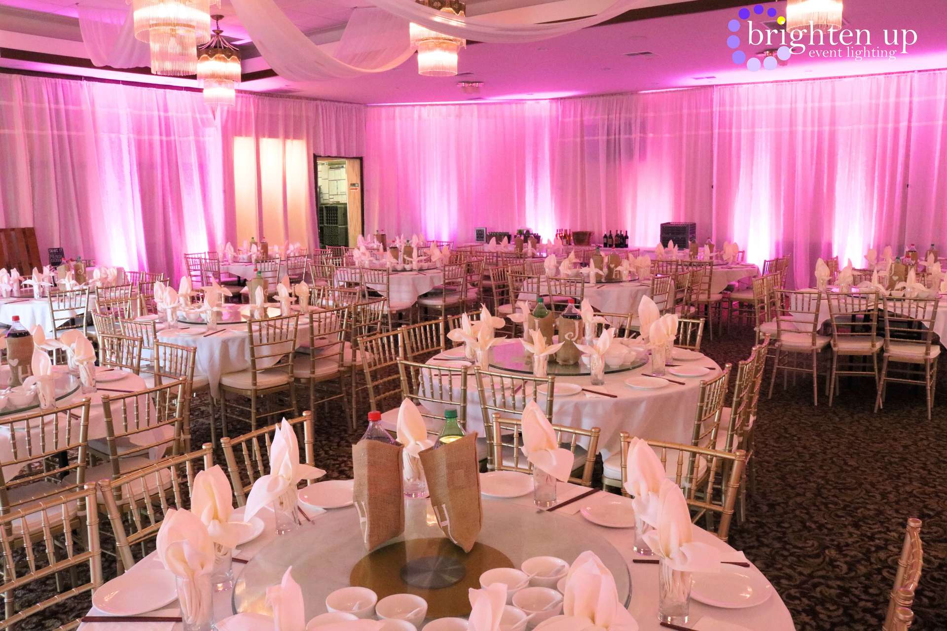 A large room with tables and chairs set up for a wedding reception.