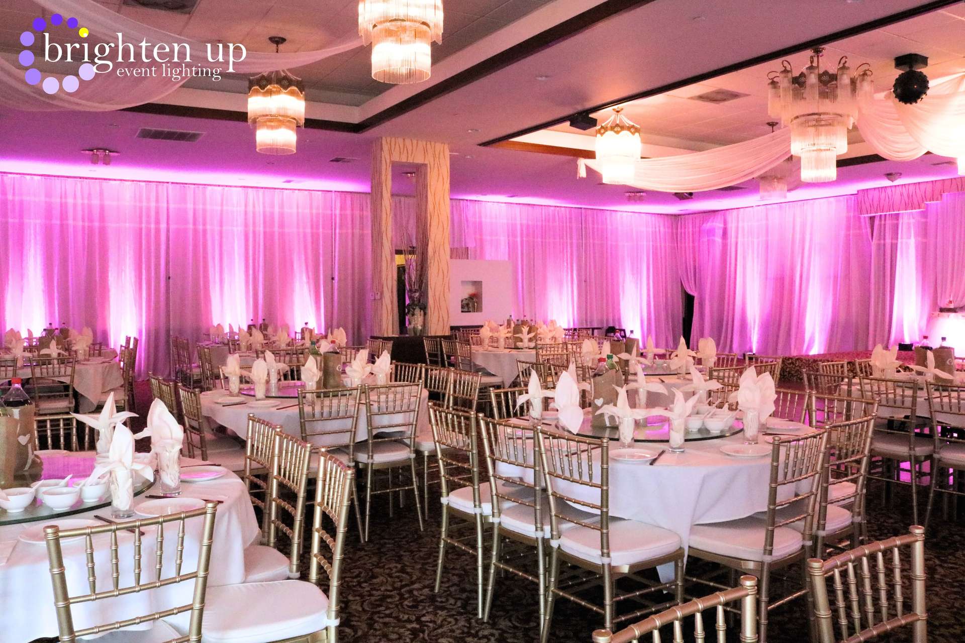A large room with tables and chairs set up for a wedding reception.
