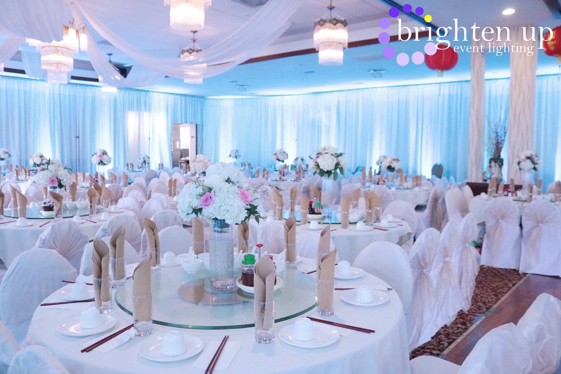 A large room with tables and chairs set up for a wedding reception.
