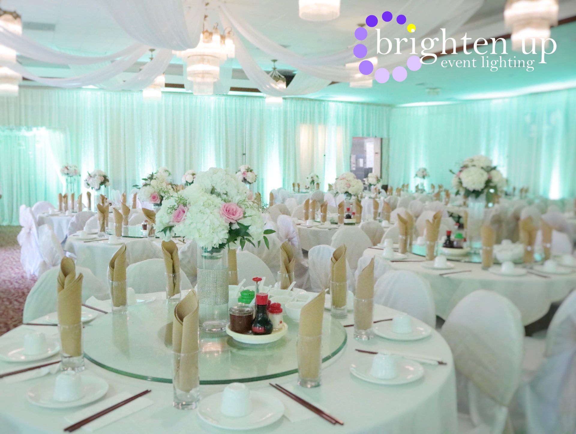 A large room with tables and chairs set up for a wedding reception
