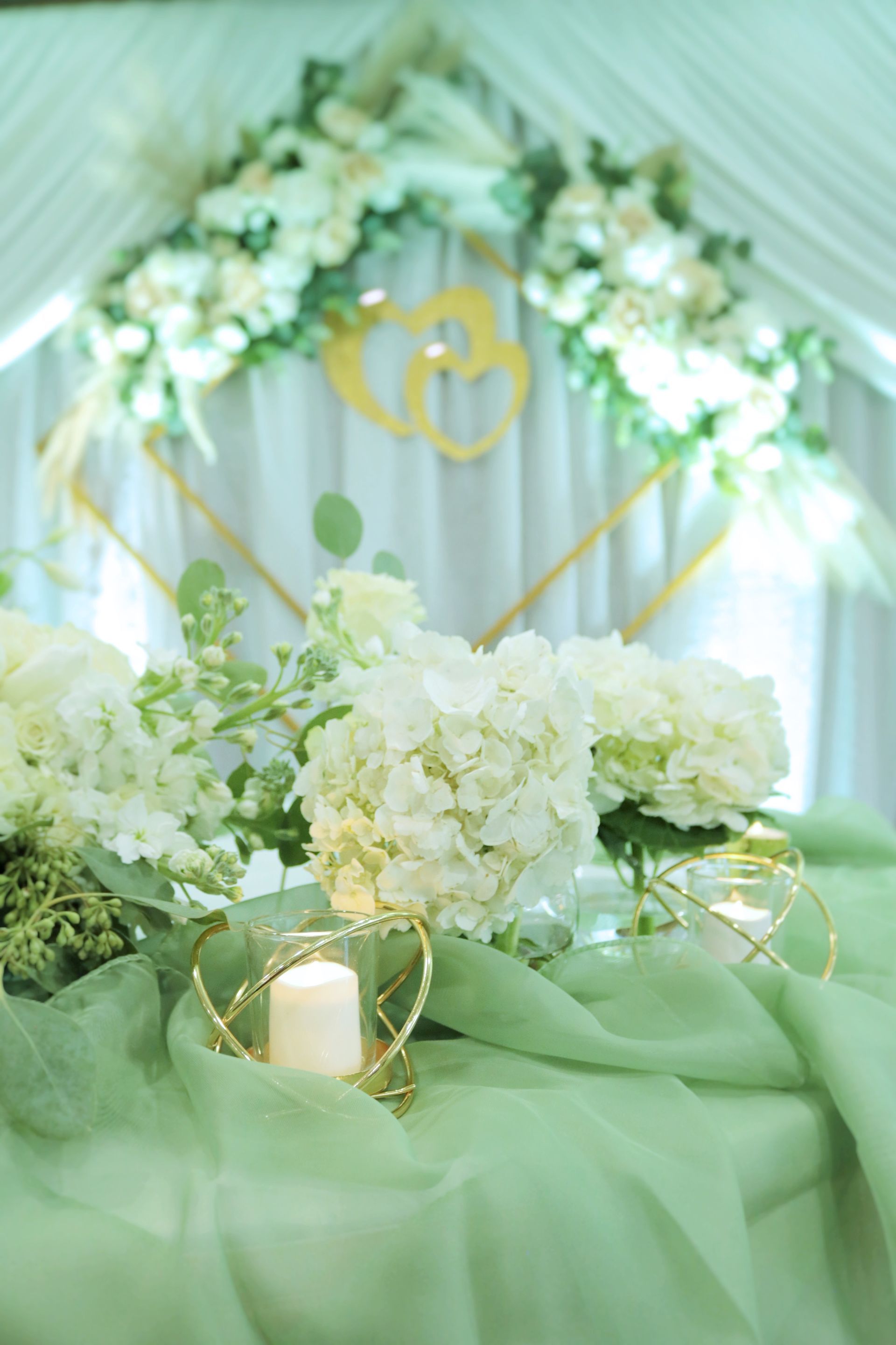 A table with white flowers and candles on it.