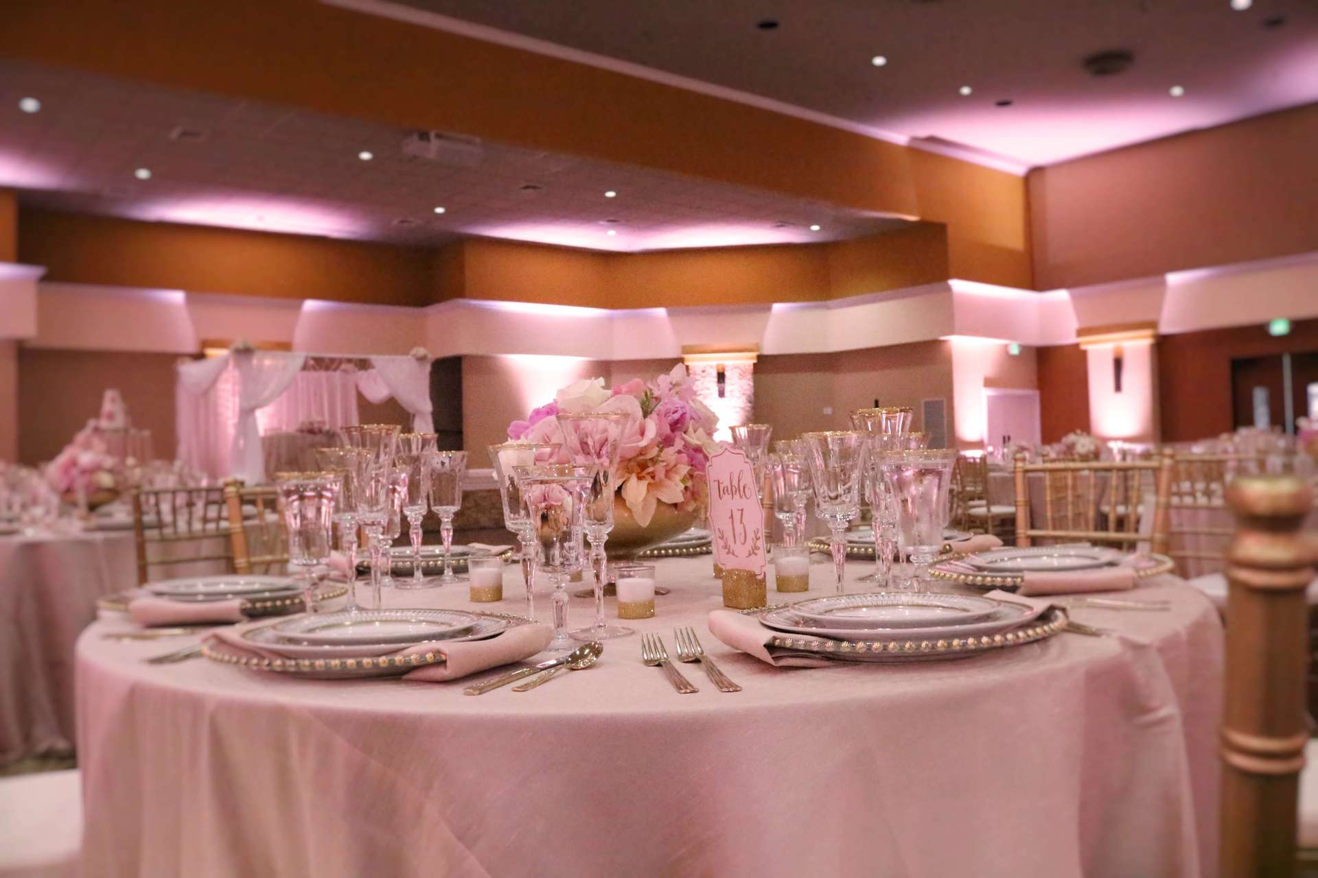 A large room with tables and chairs set up for a wedding reception.
