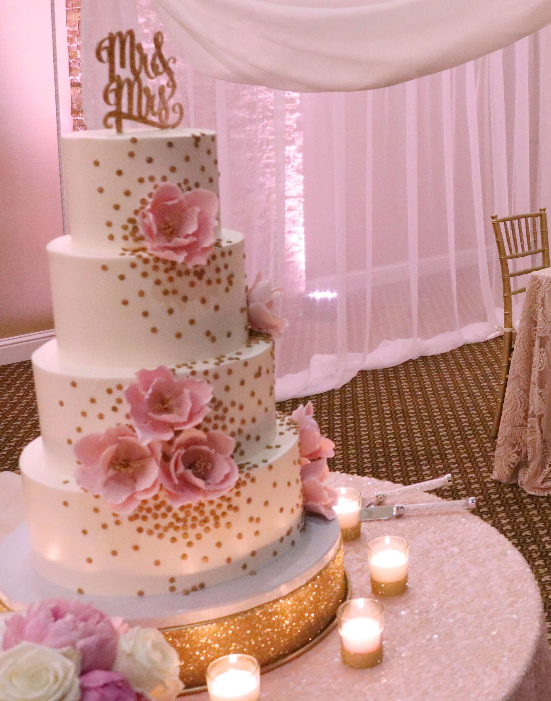 A wedding cake with flowers and candles on a table