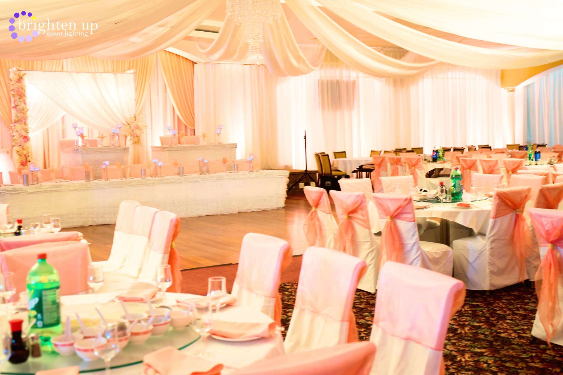 A large room with tables and chairs set up for a wedding reception.