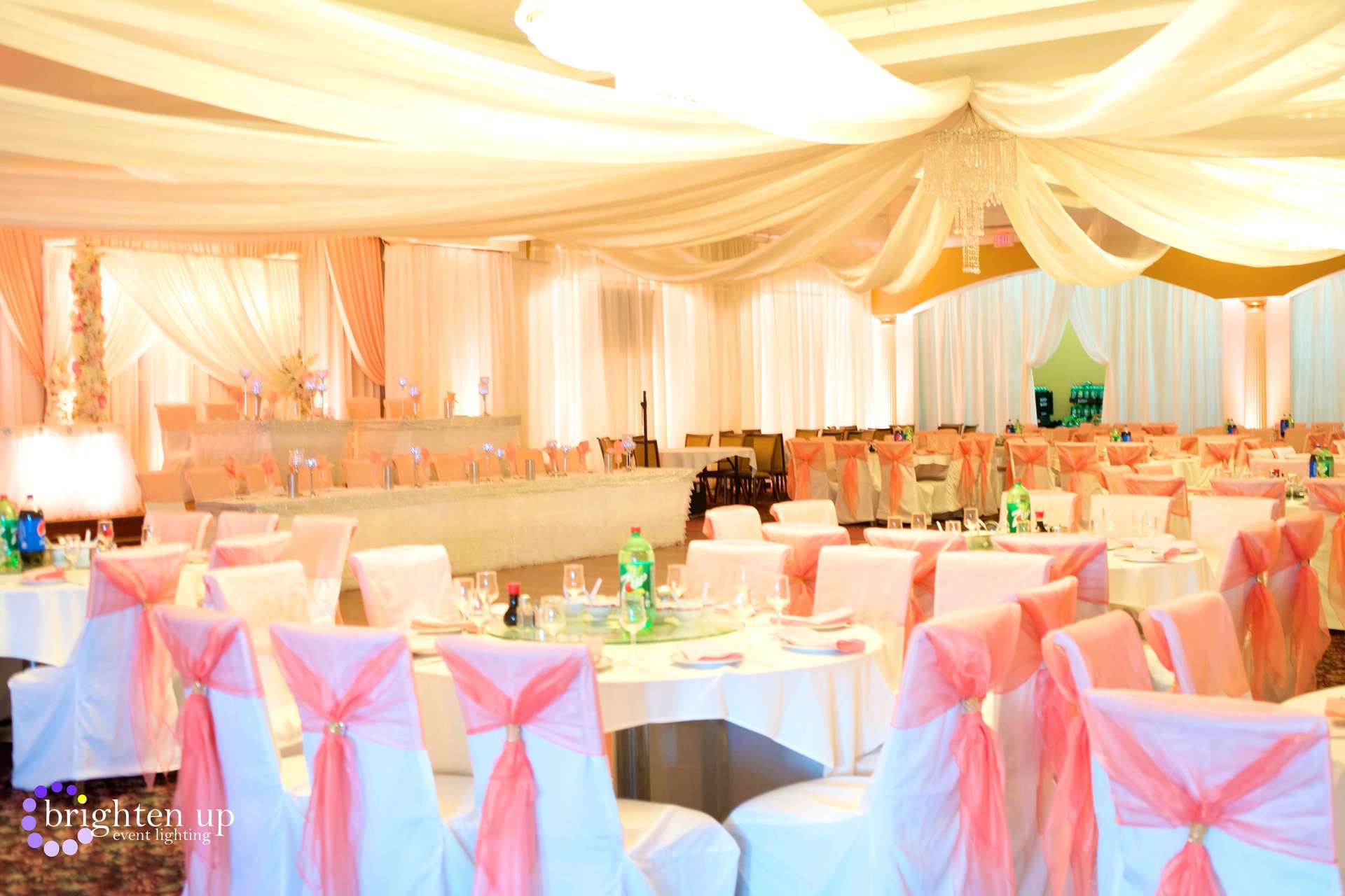 A large room with tables and chairs set up for a wedding reception.