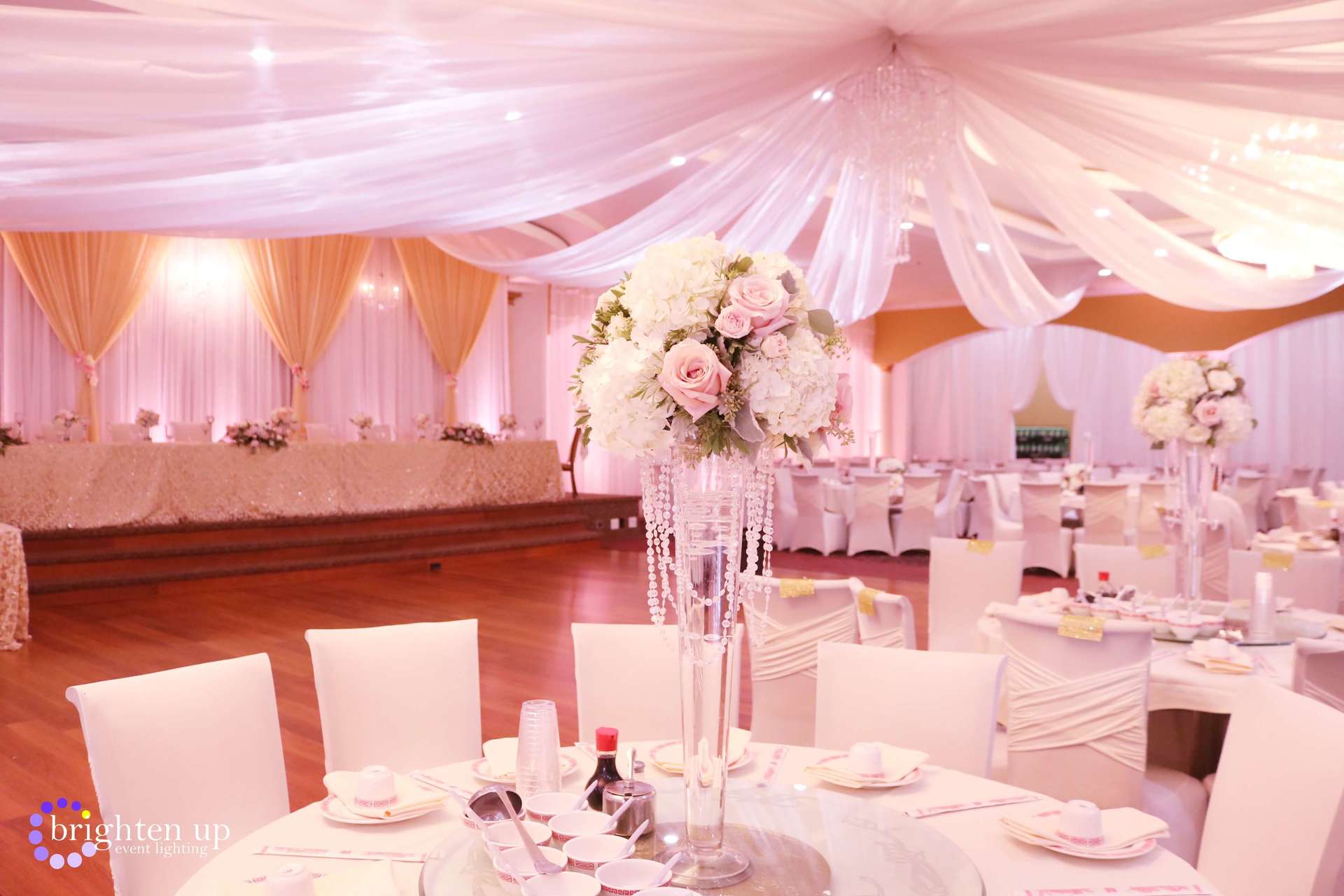 A large room with tables and chairs set up for a wedding reception.