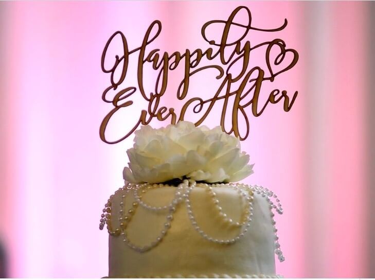 A wedding cake with a topper that says happily ever after