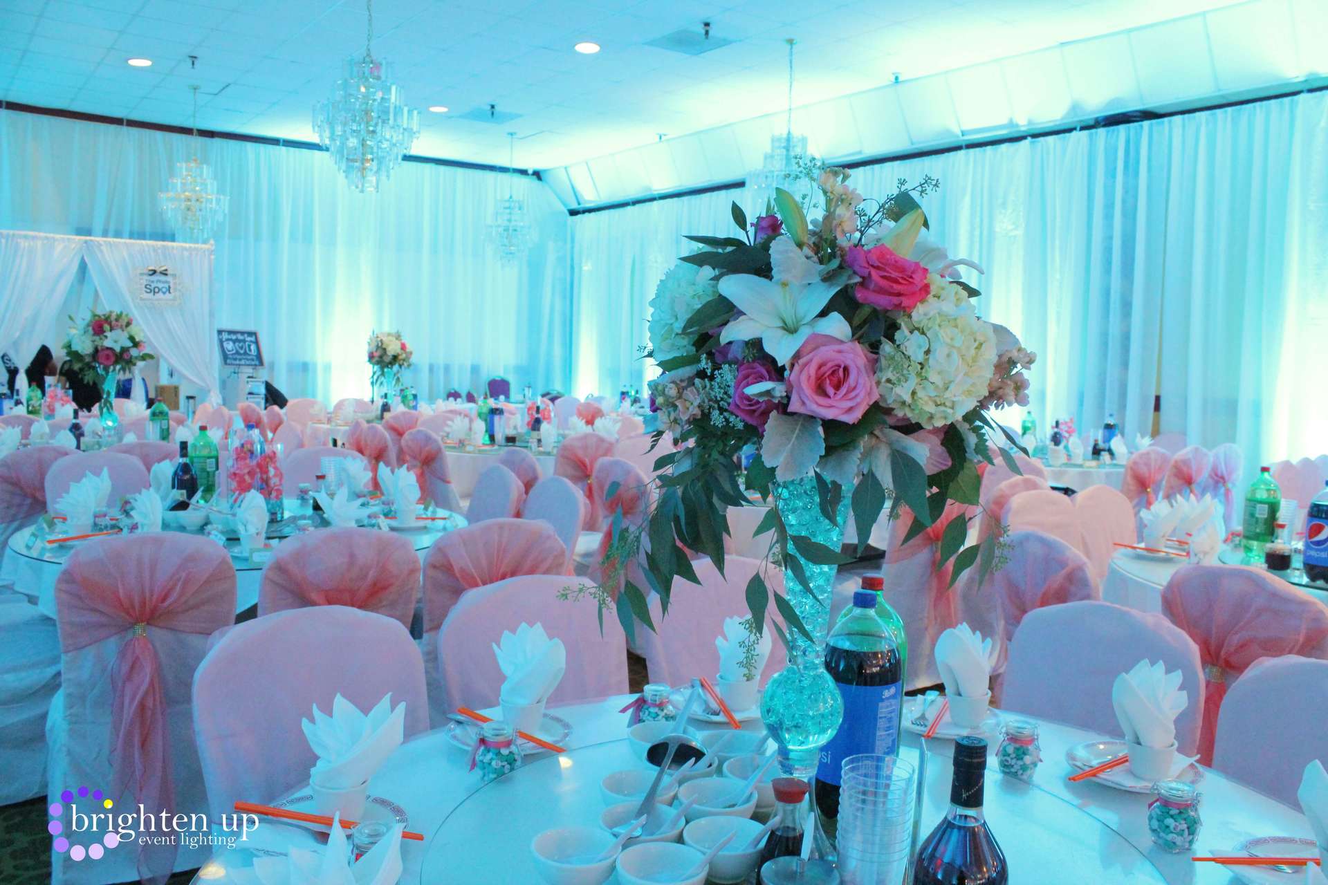 A large room with tables and chairs set up for a wedding reception.