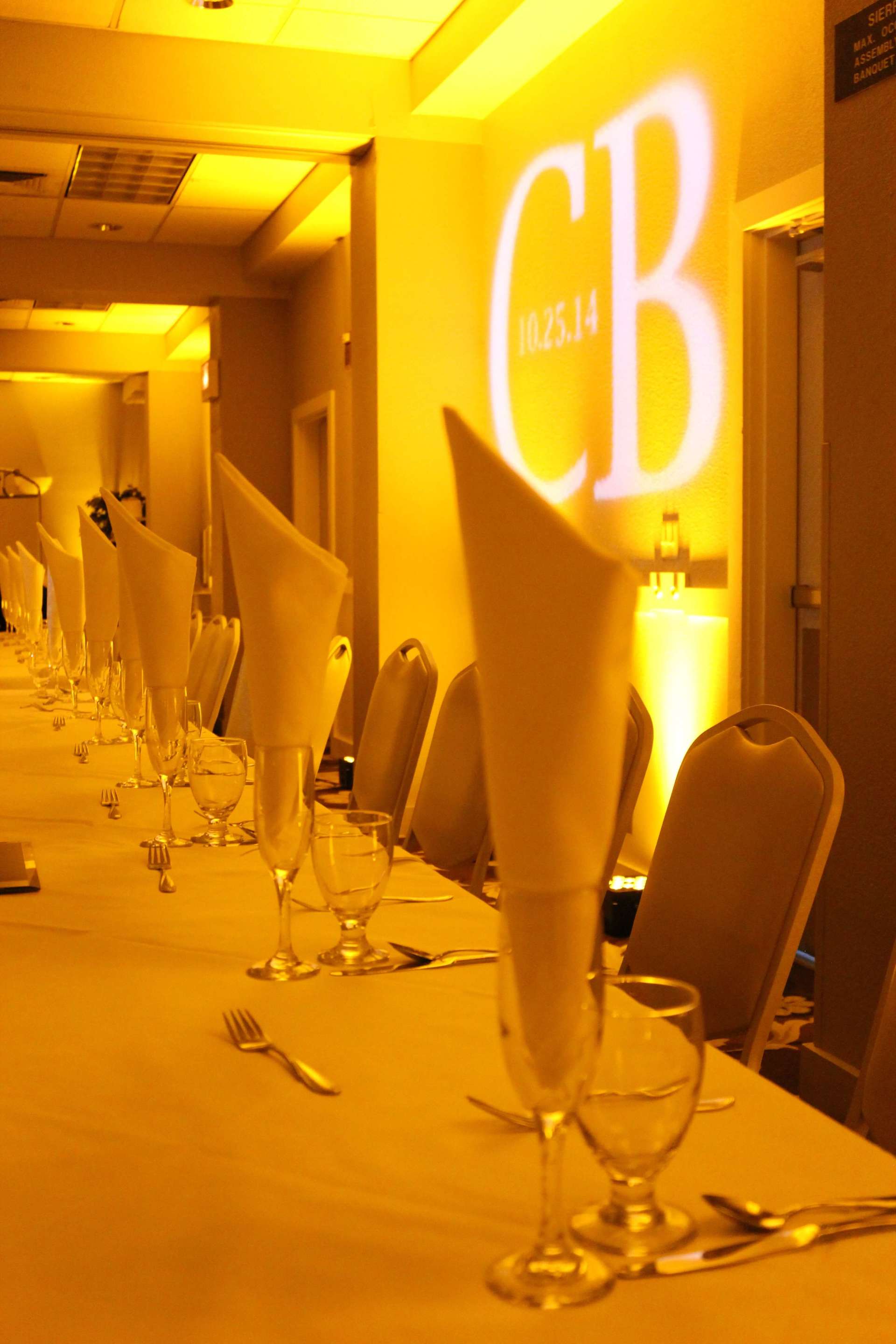 A long table with a monogram on the wall behind it