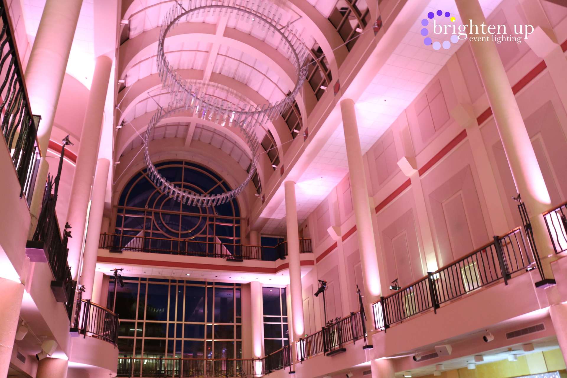 A large building with pink lights on the ceiling