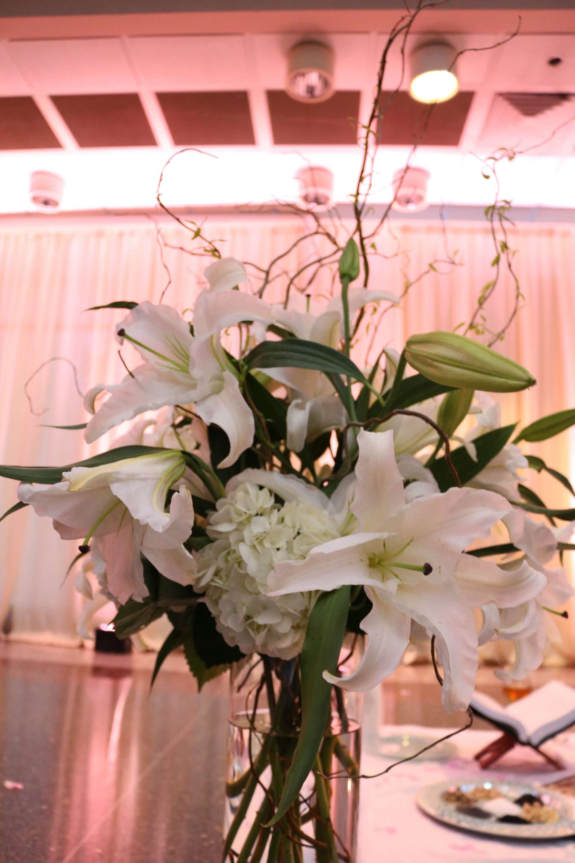 A vase filled with white flowers is sitting on a table.