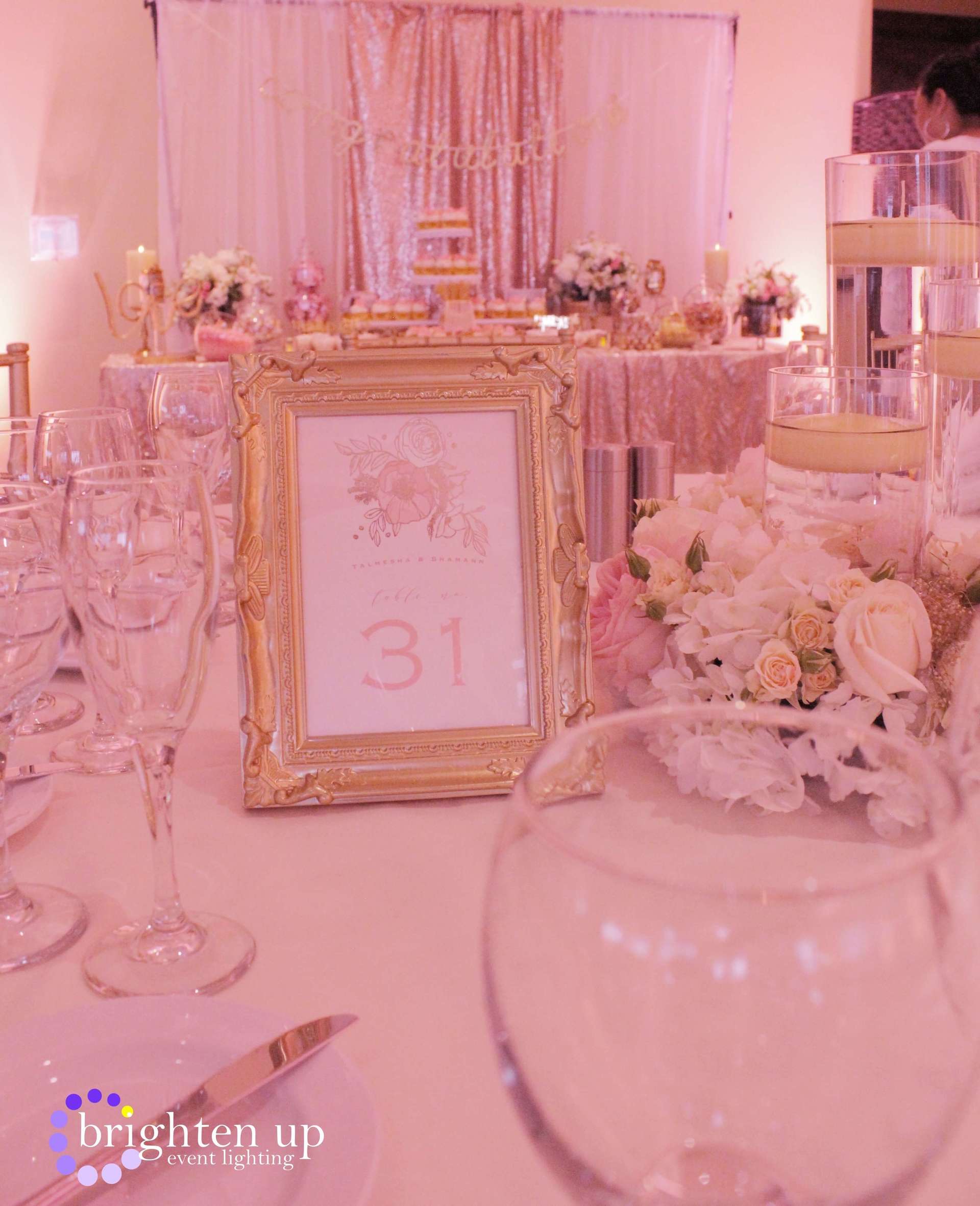 A table set for a wedding reception with a picture frame with the number 31 on it.