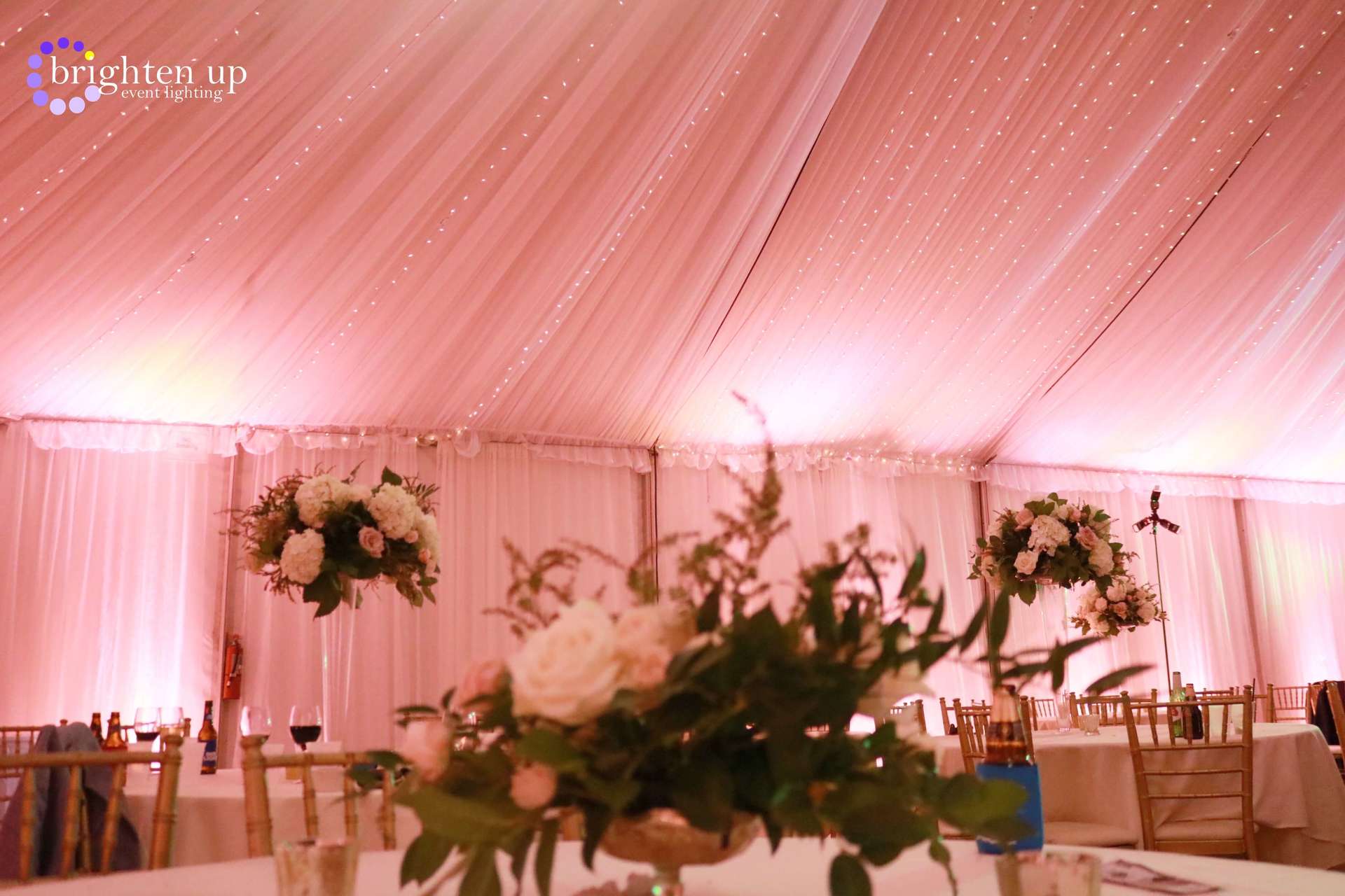 A table with flowers on it in a tent.