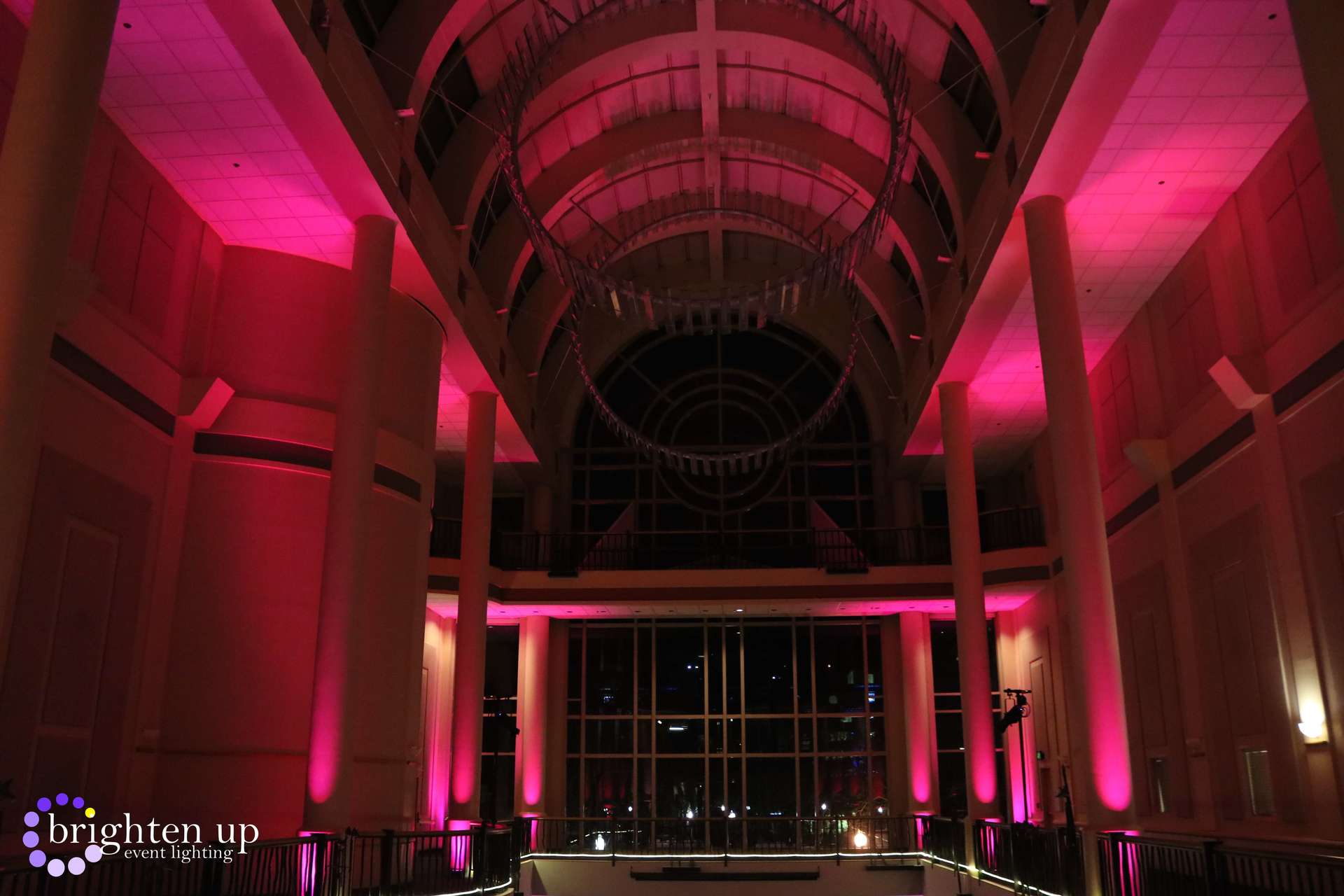 A large building with pink lights on the ceiling