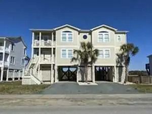 A large house with a lot of windows and palm trees in front of it.