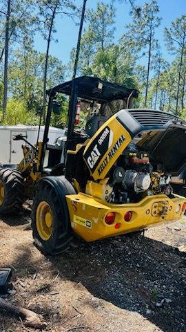 a yellow and black tractor with the hood open is parked in the dirt . — Naples, FL — Affordable Pros Removal Services LLC