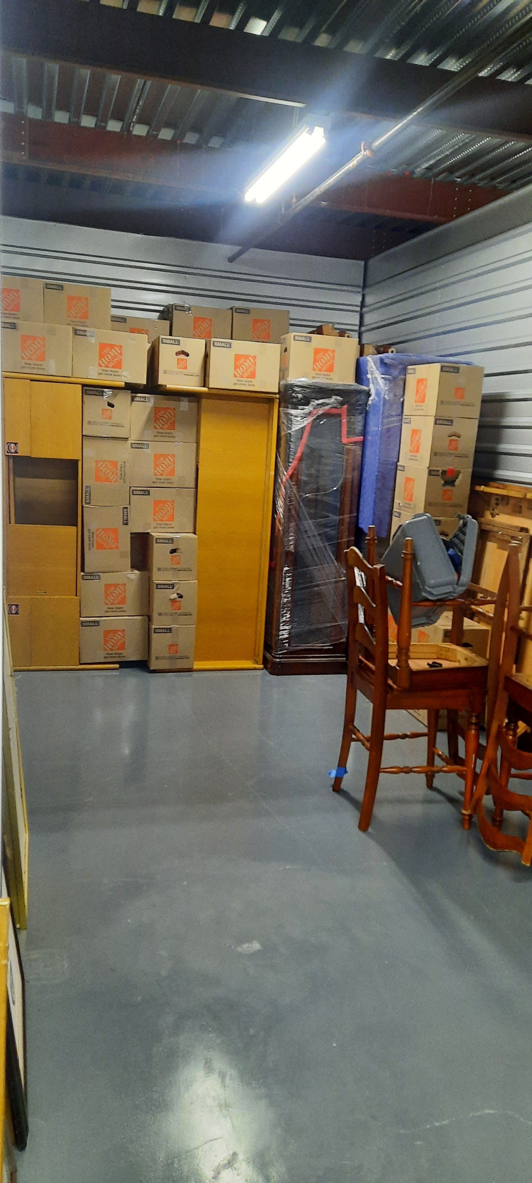A warehouse filled with lots of boxes and chairs.