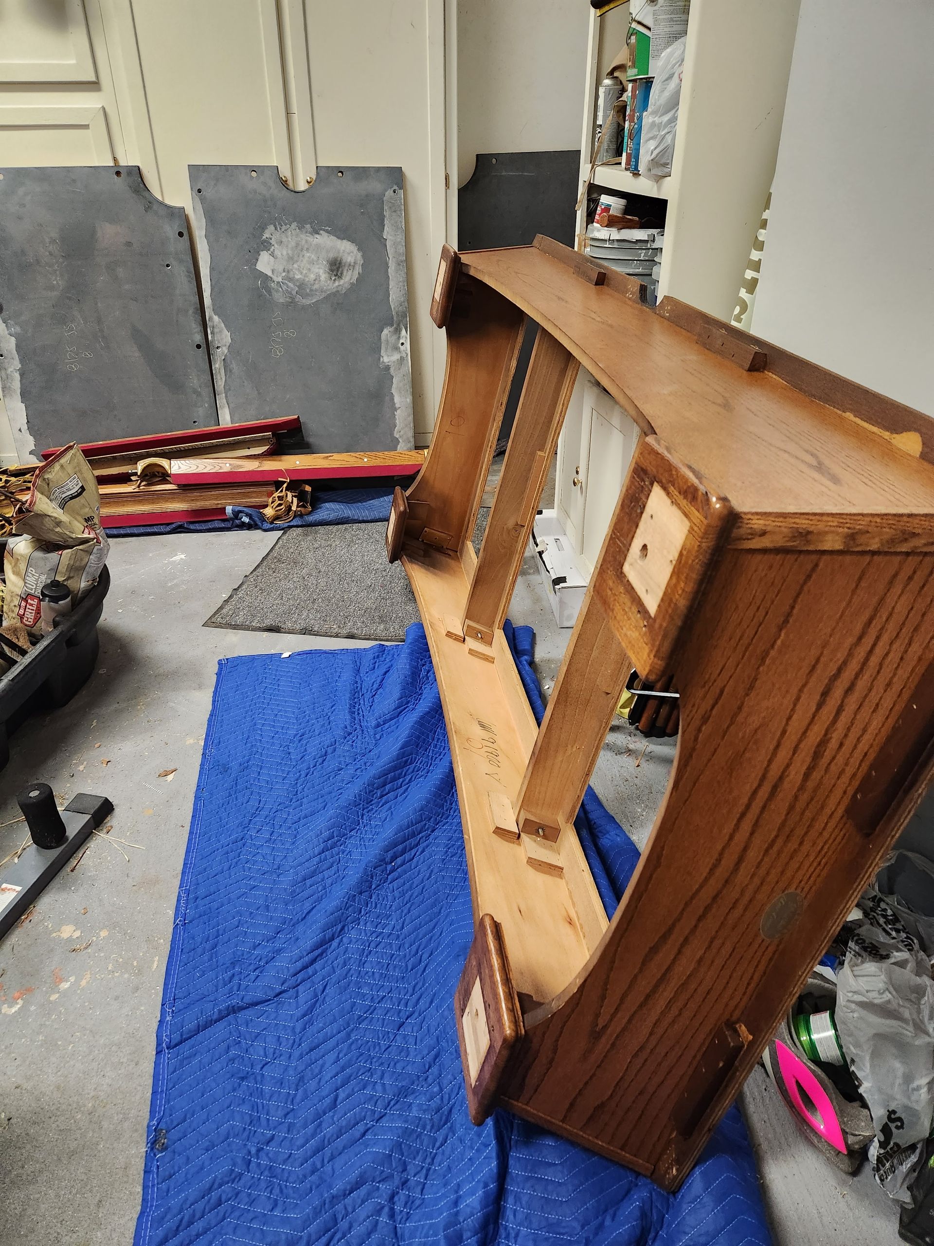 A wooden dresser is sitting on top of a blue blanket in a room.