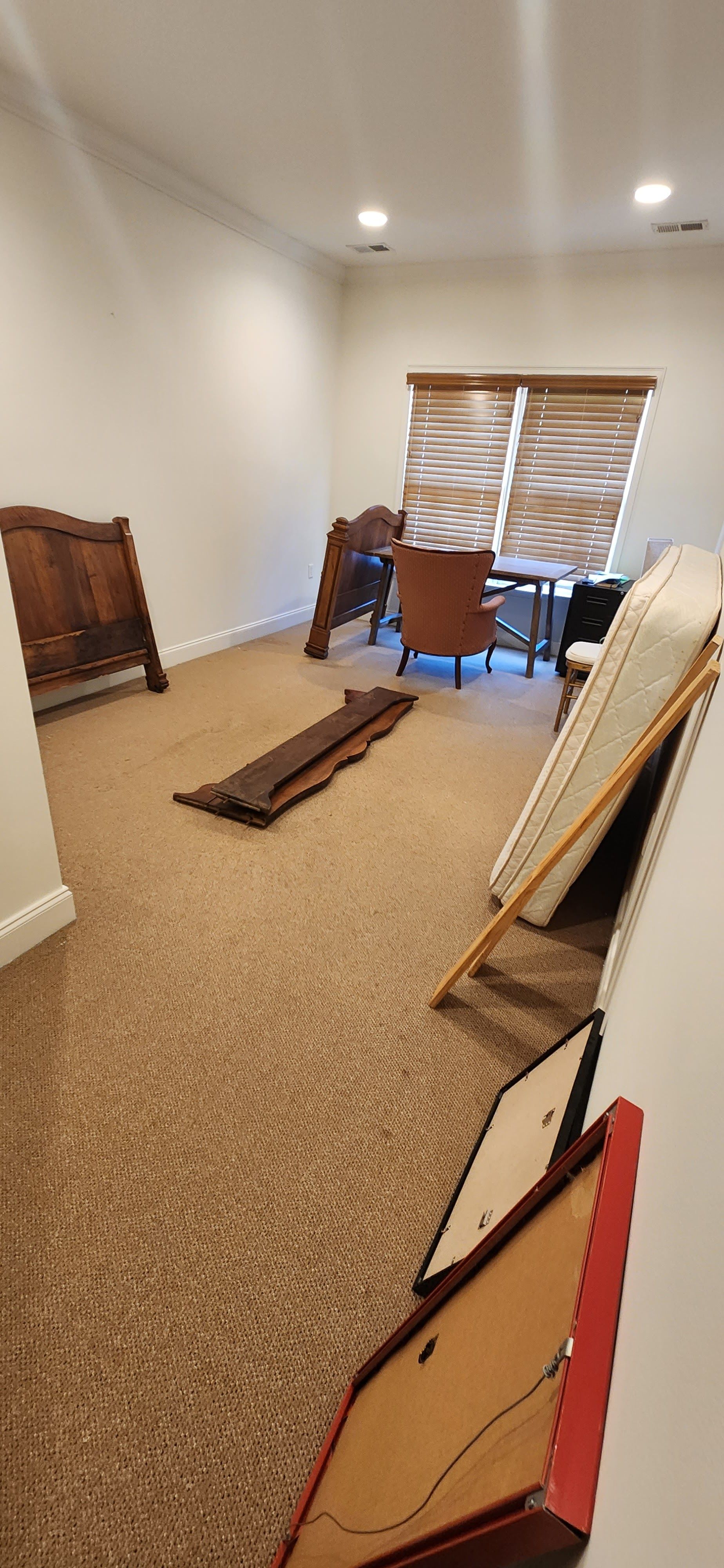 A room with a lot of furniture on the floor and a window.