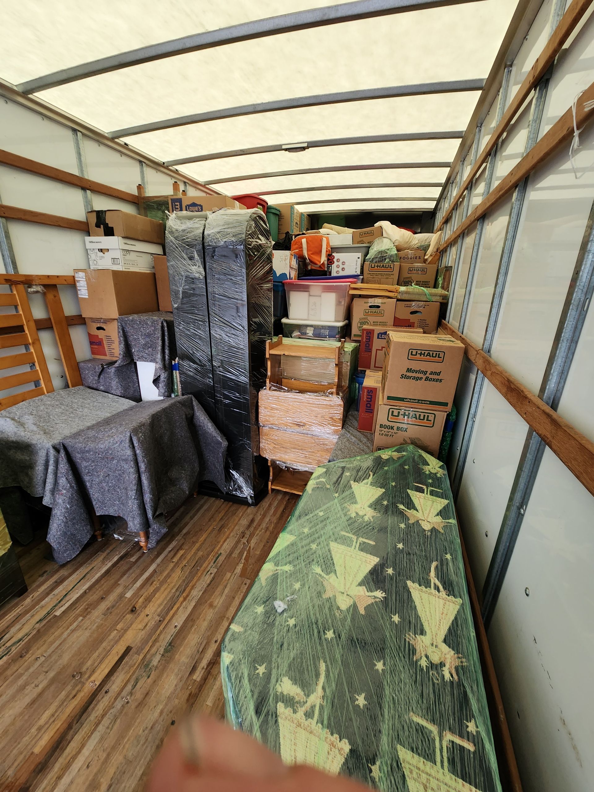 The inside of a moving truck filled with boxes and furniture.