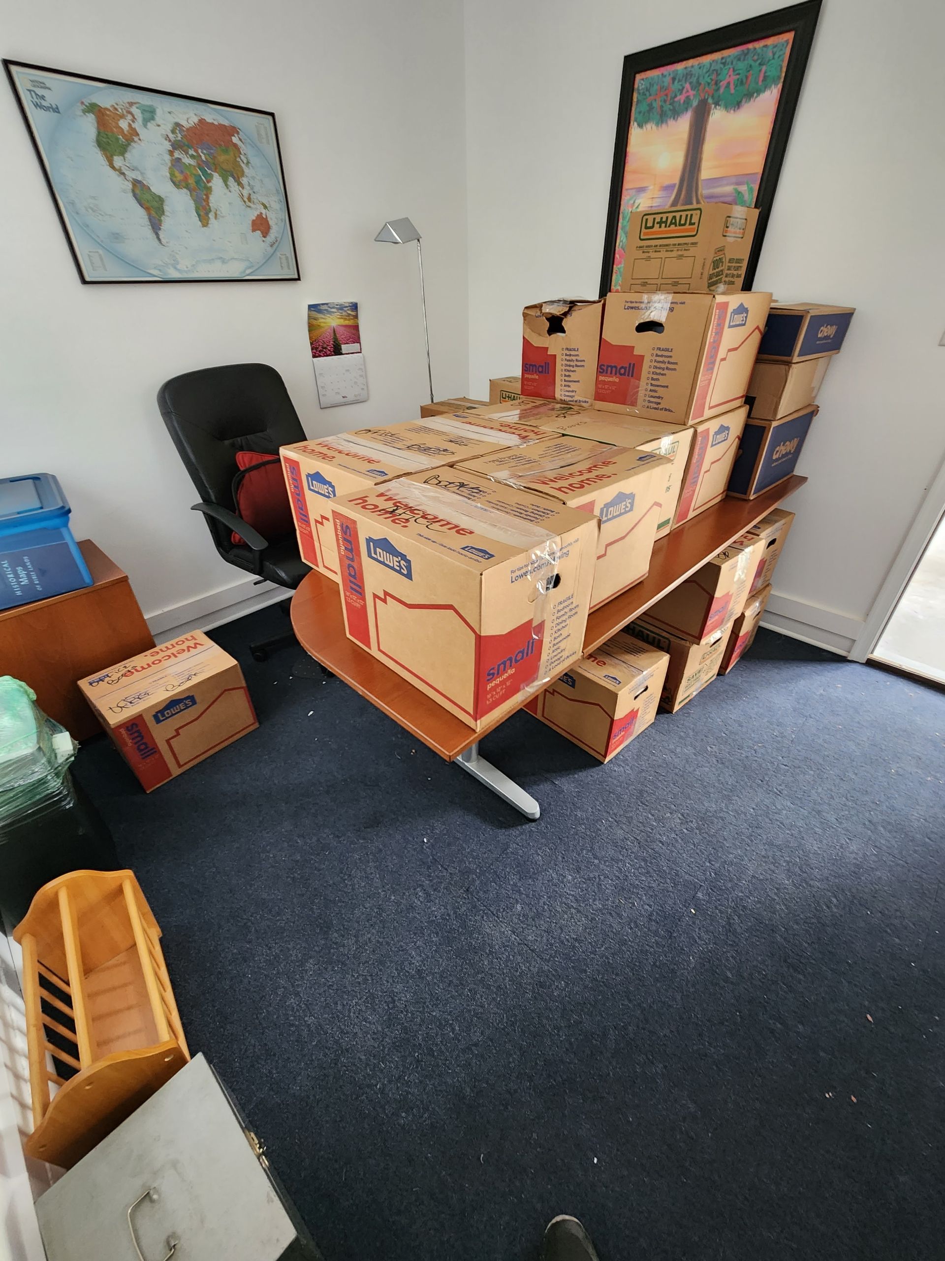 Boxes are stacked on top of a desk in a room