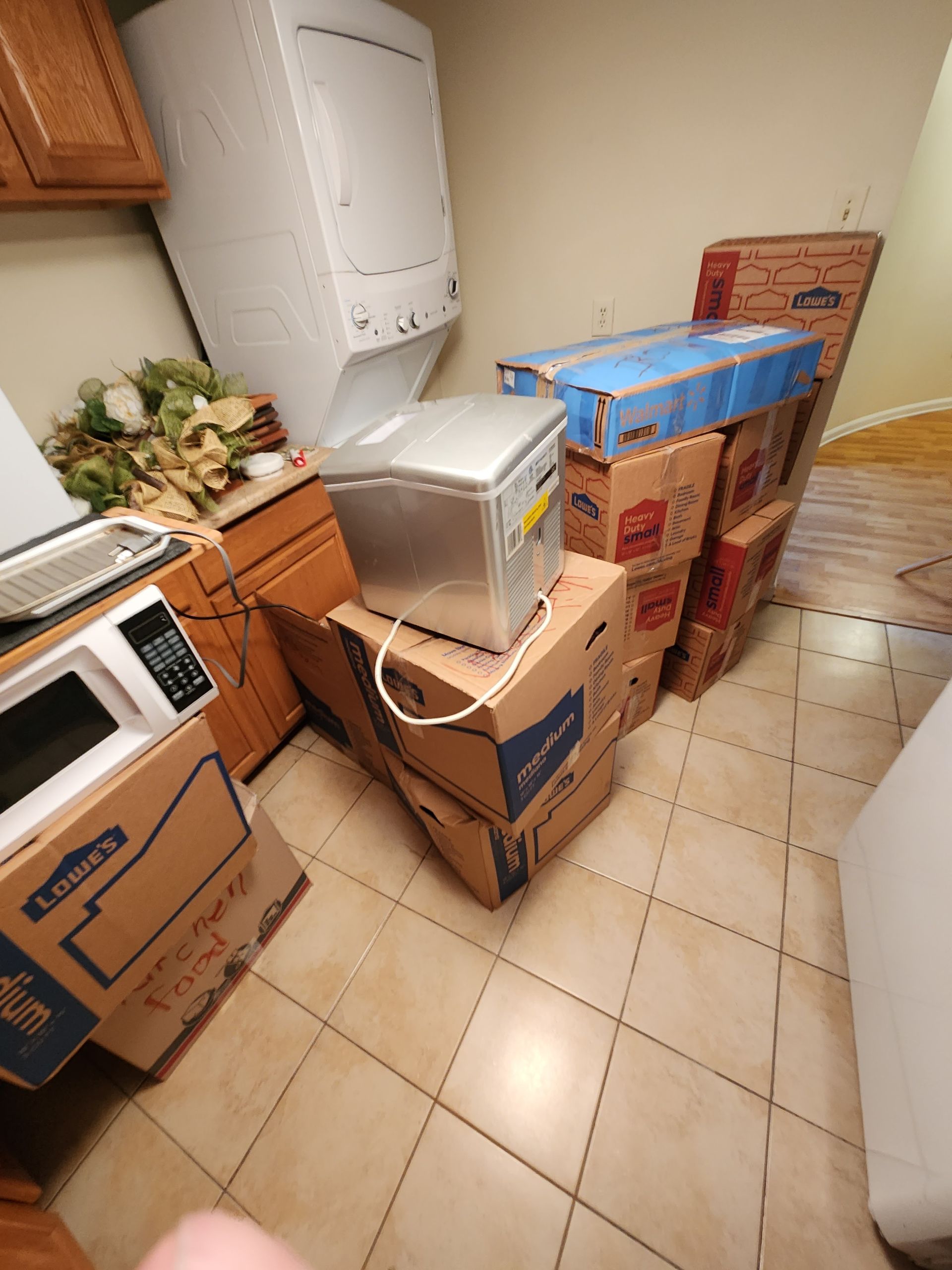 A kitchen with a stack of boxes and a microwave