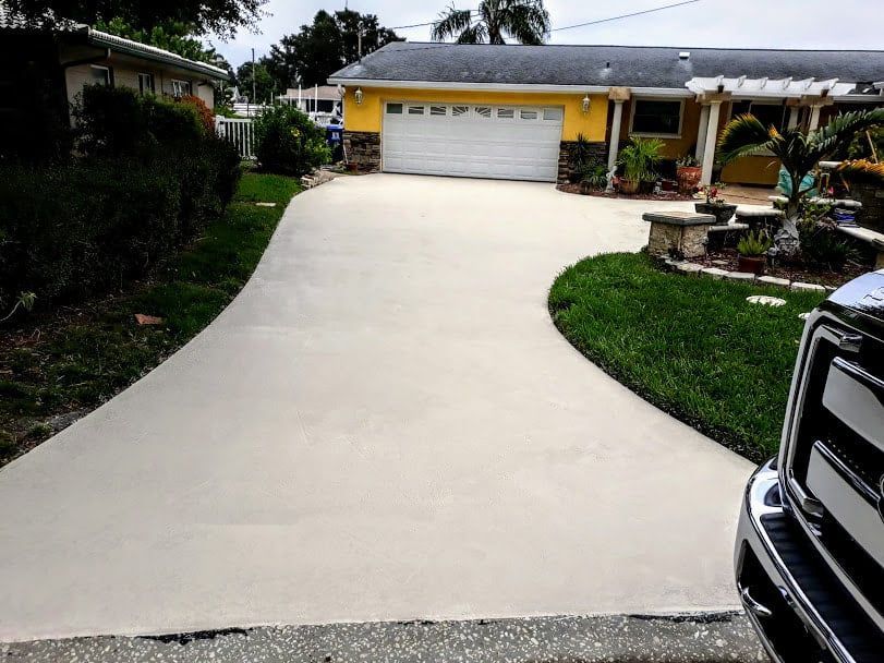 A truck is parked in front of a yellow house with a white garage door.