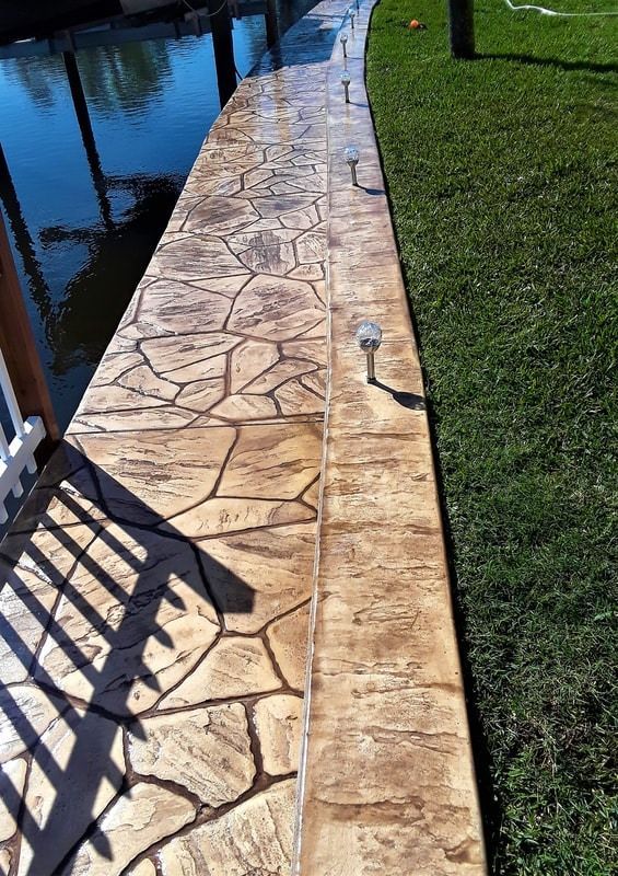 A concrete walkway leading to a body of water.