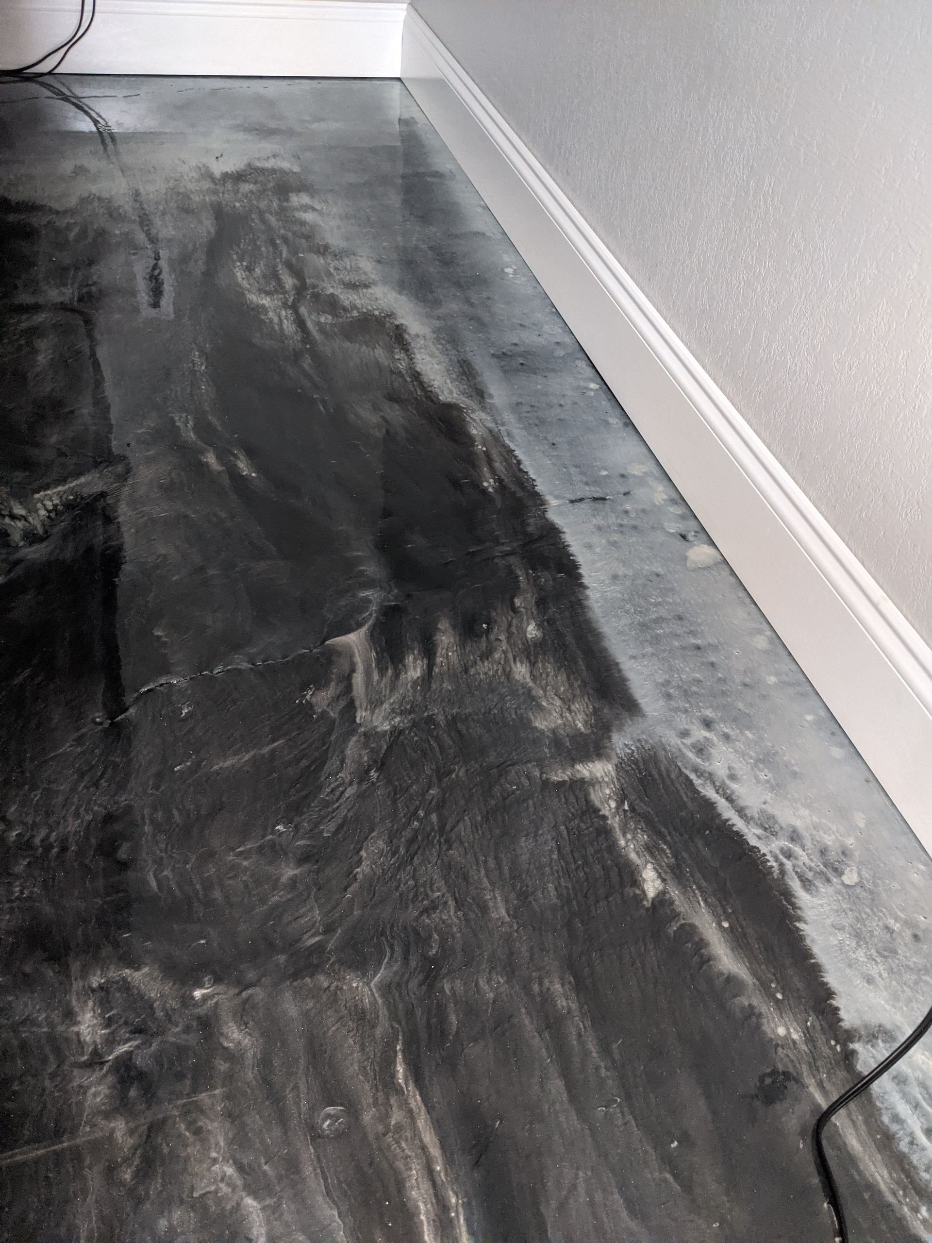 A close up of a black marble floor in a room.