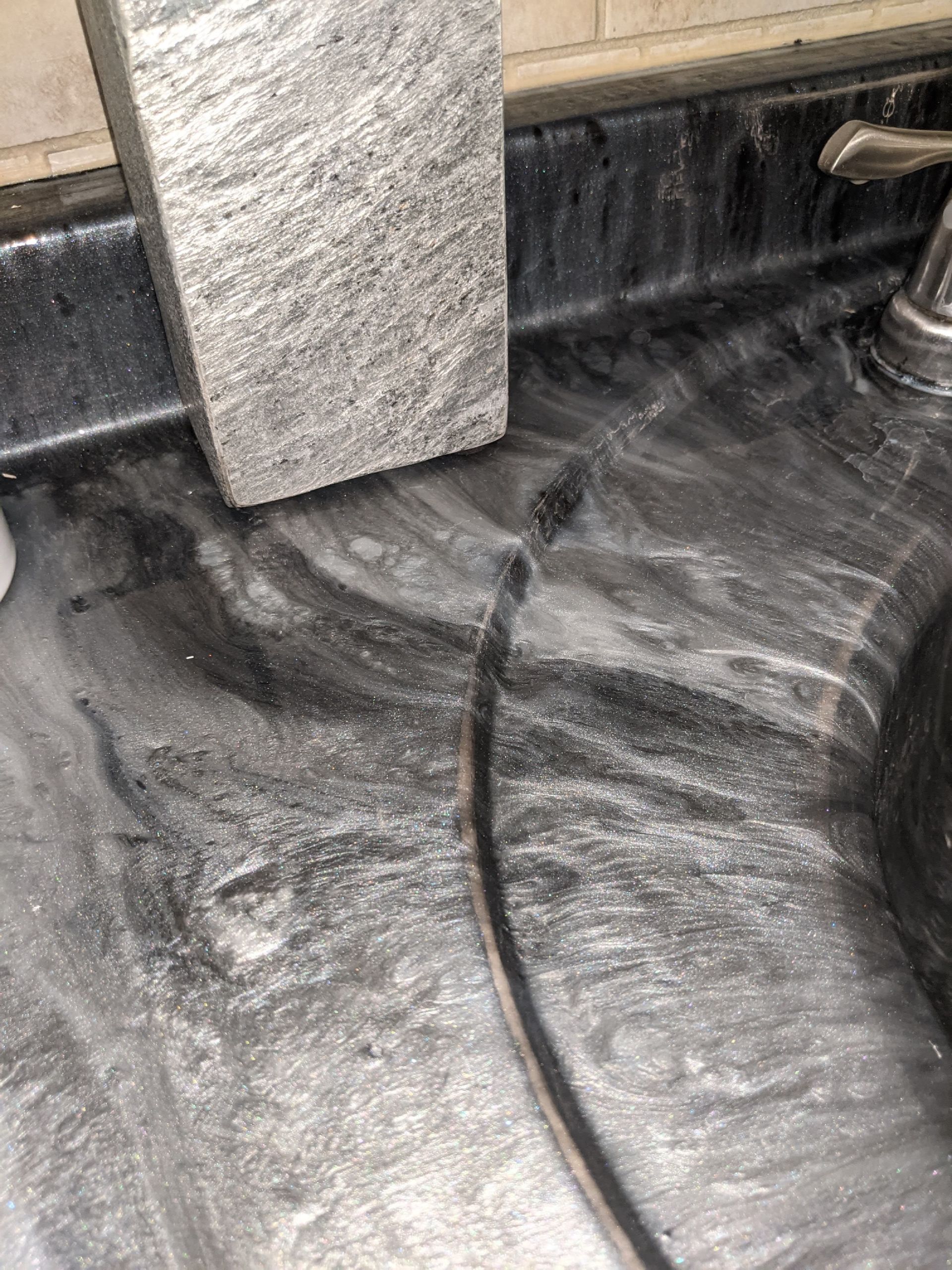 A close up of a sink with a sponge on it.