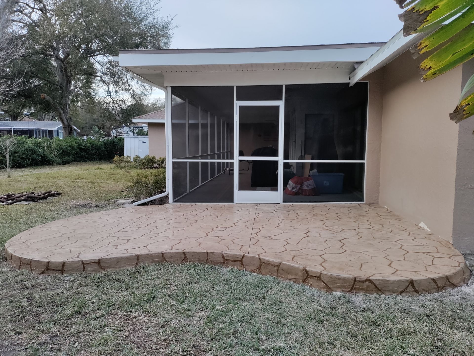 A screened in porch in the backyard of a house