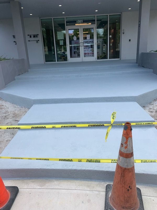 A concrete walkway is being built in front of a building.