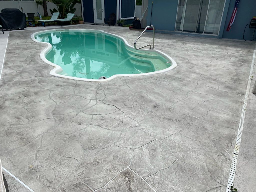 There is a large swimming pool in the backyard of a house.