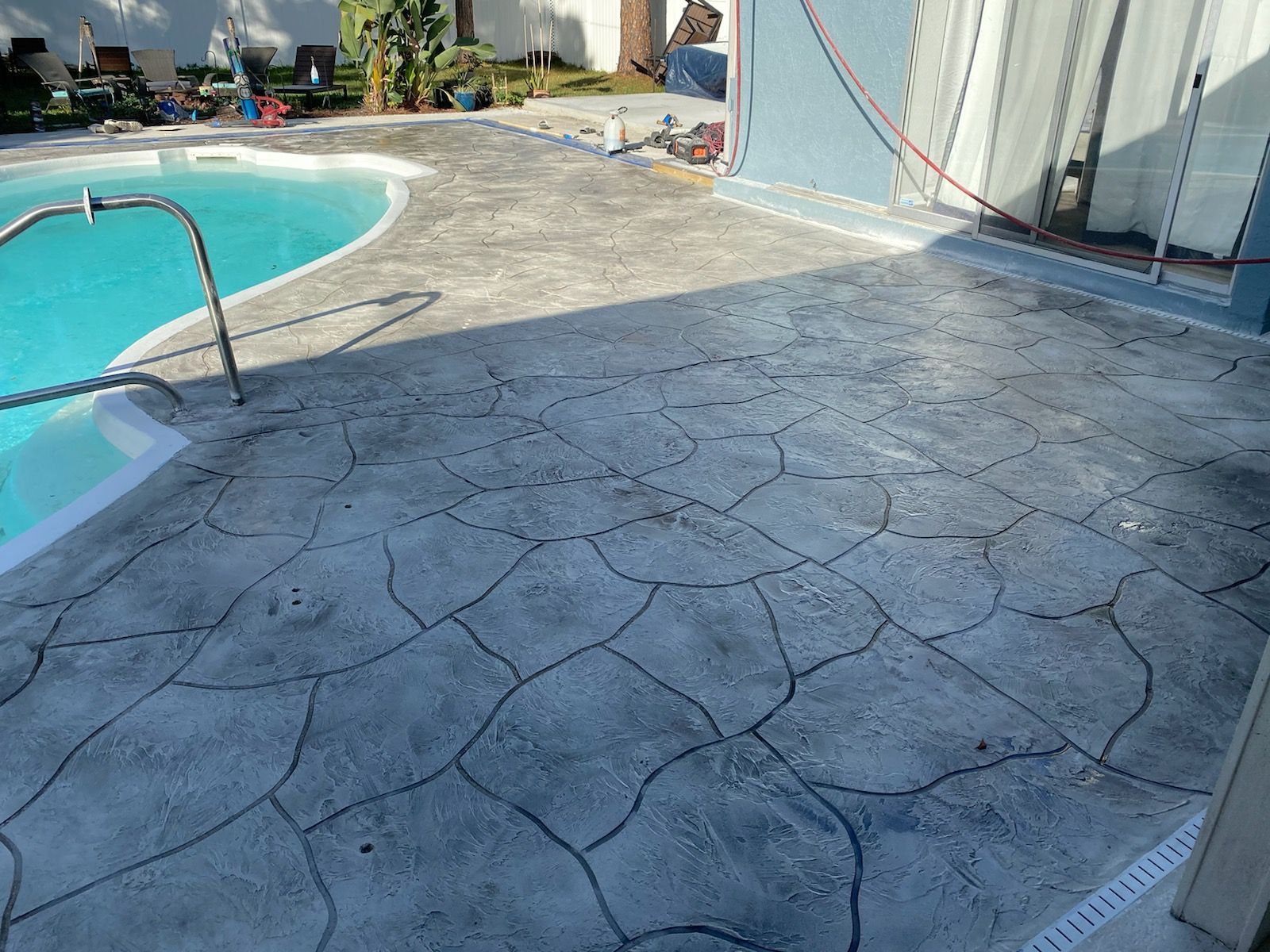 A swimming pool with a concrete deck in front of it