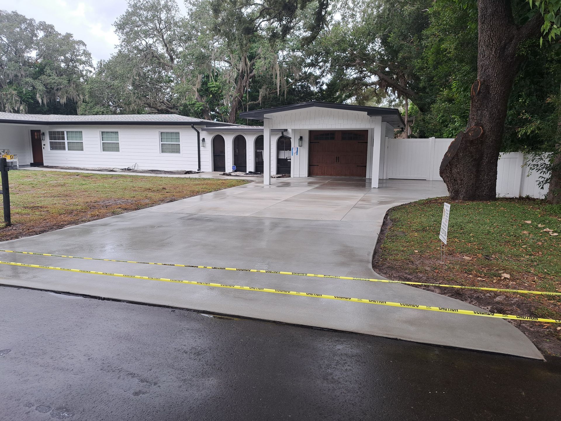 A white house with a concrete driveway and a garage