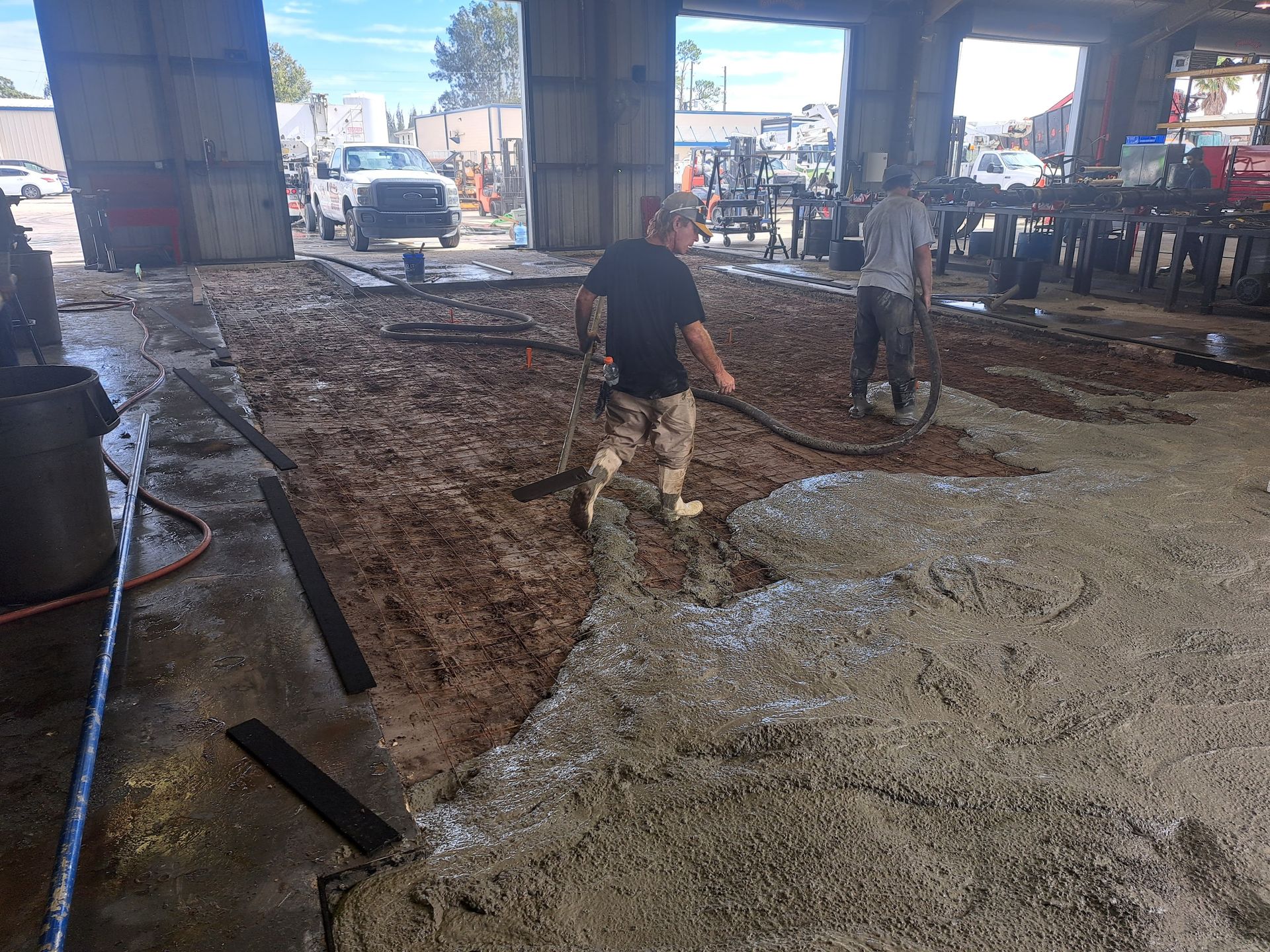 A man is pumping concrete into a building with a hose.