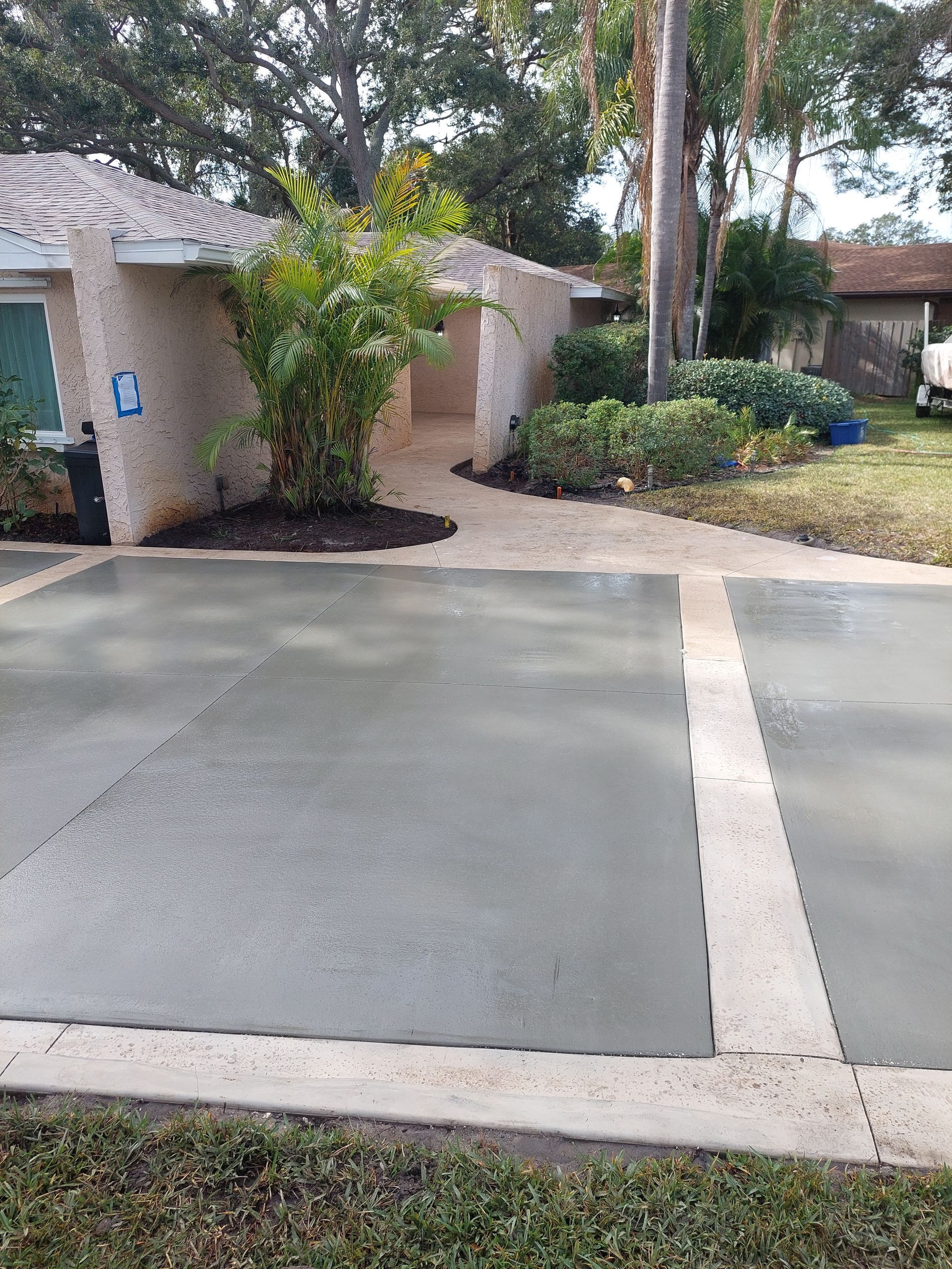 A concrete driveway in front of a house with a handicap sign.
