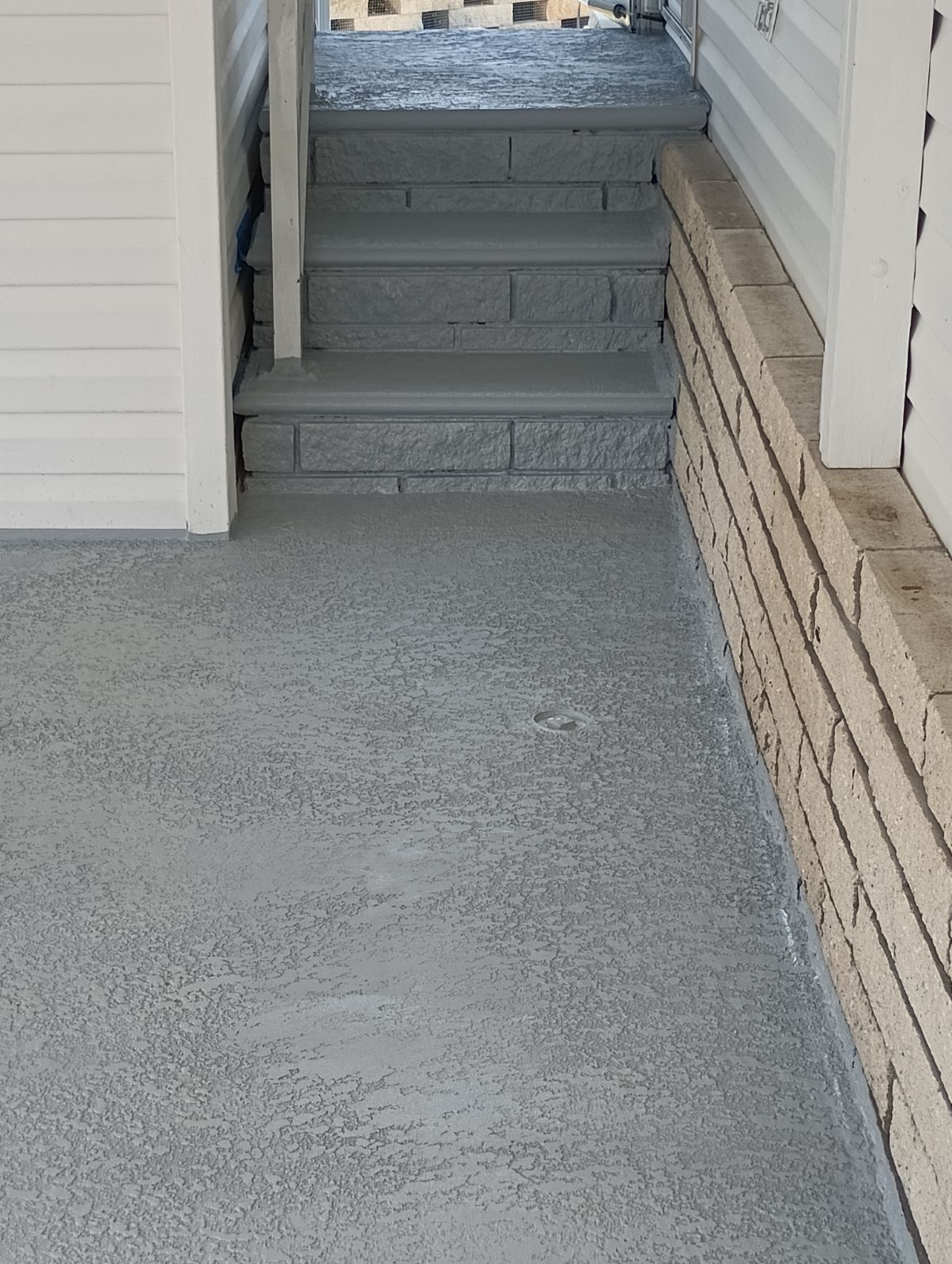 A staircase with a brick wall and a concrete floor