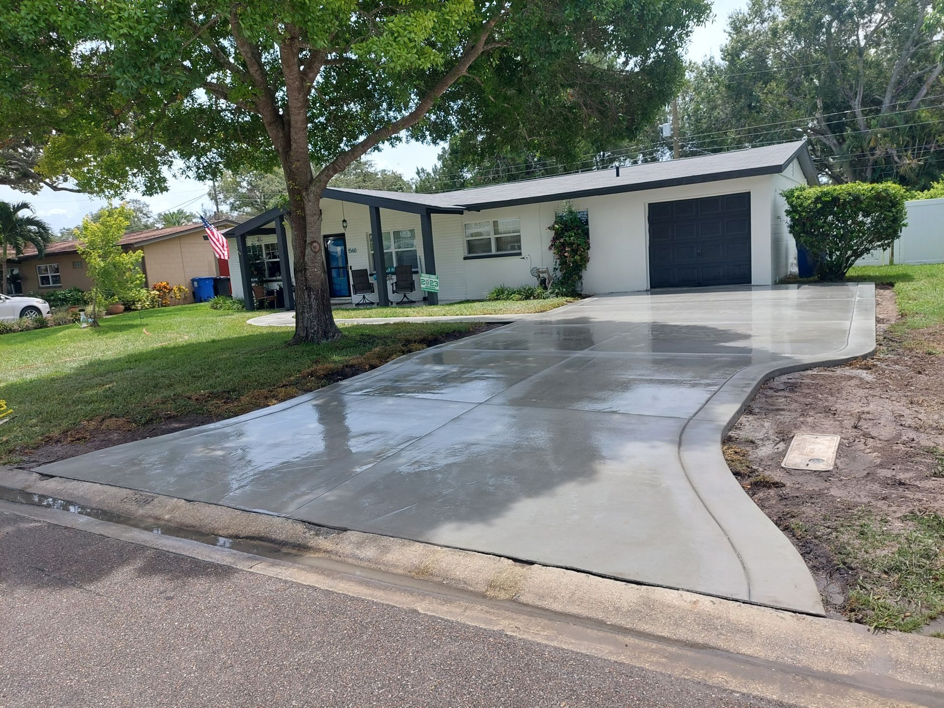 A concrete driveway is being built in front of a house.