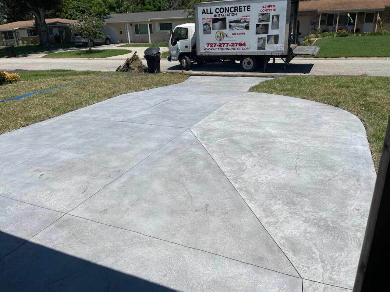 A white truck is parked in a driveway next to a house.