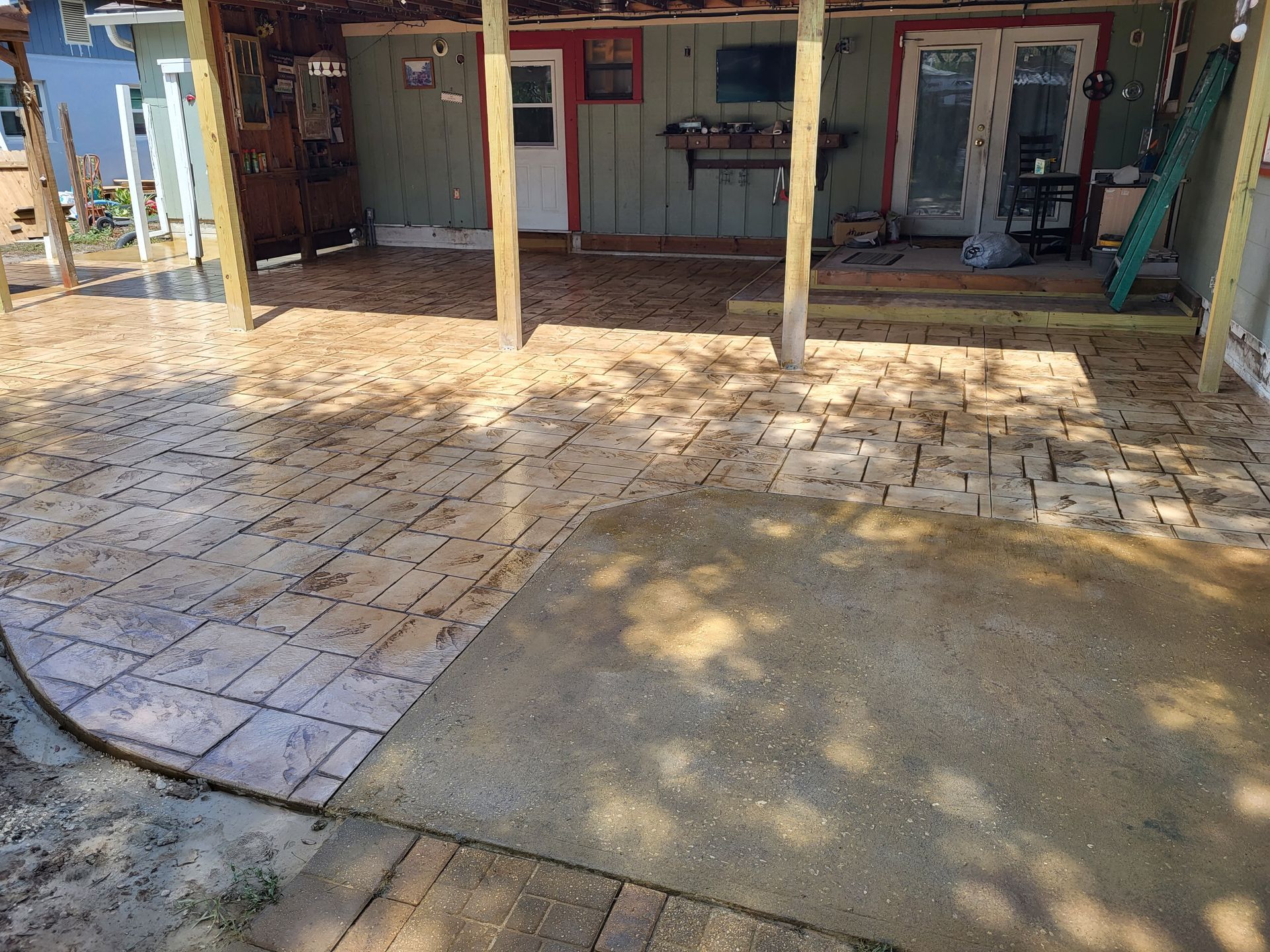 A patio with a brick walkway leading to a house.